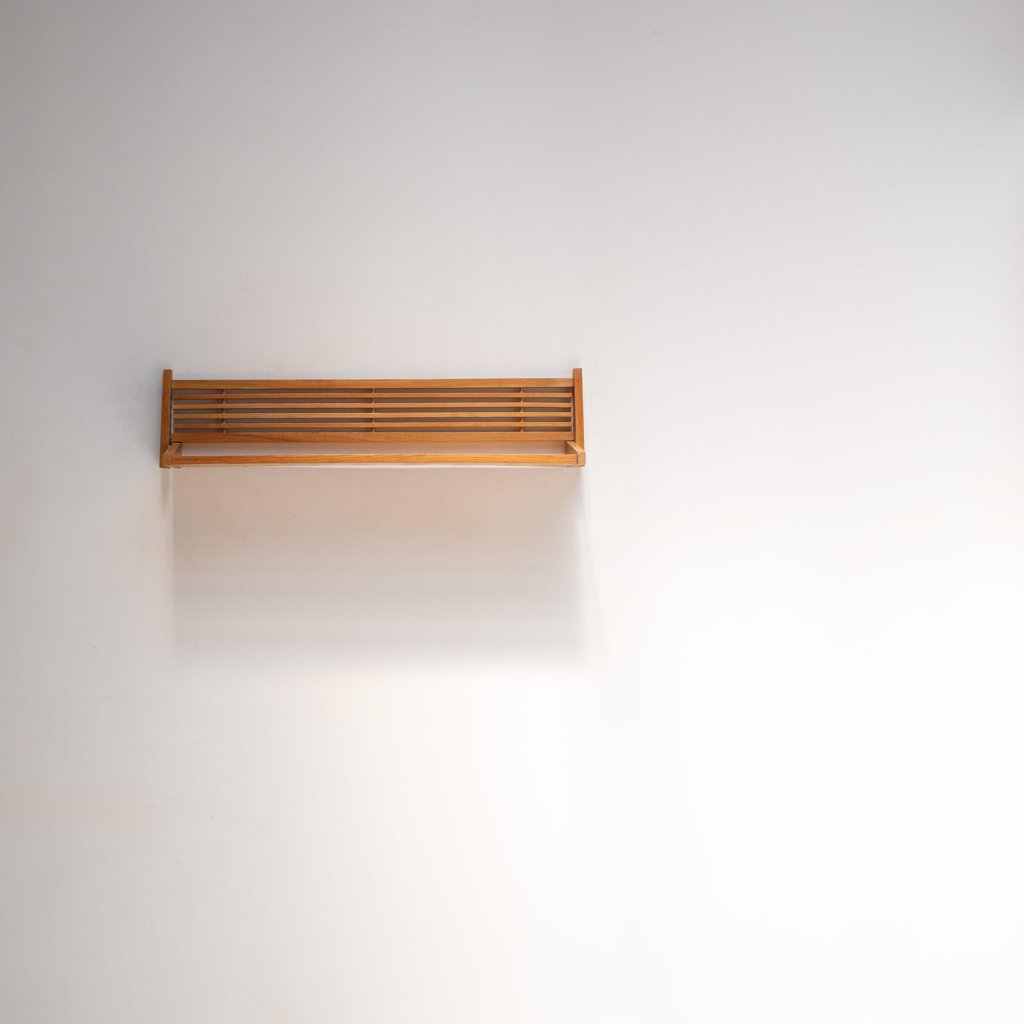 Ein raffiniertes und minimalistisches Wandregal. Dieses elegante Stück spiegelt die klaren Linien und die Ehrlichkeit der Materialien wider, die mit dem Design der Mitte des Jahrhunderts in Osteuropa verbunden sind.

Die Konstruktion besteht aus