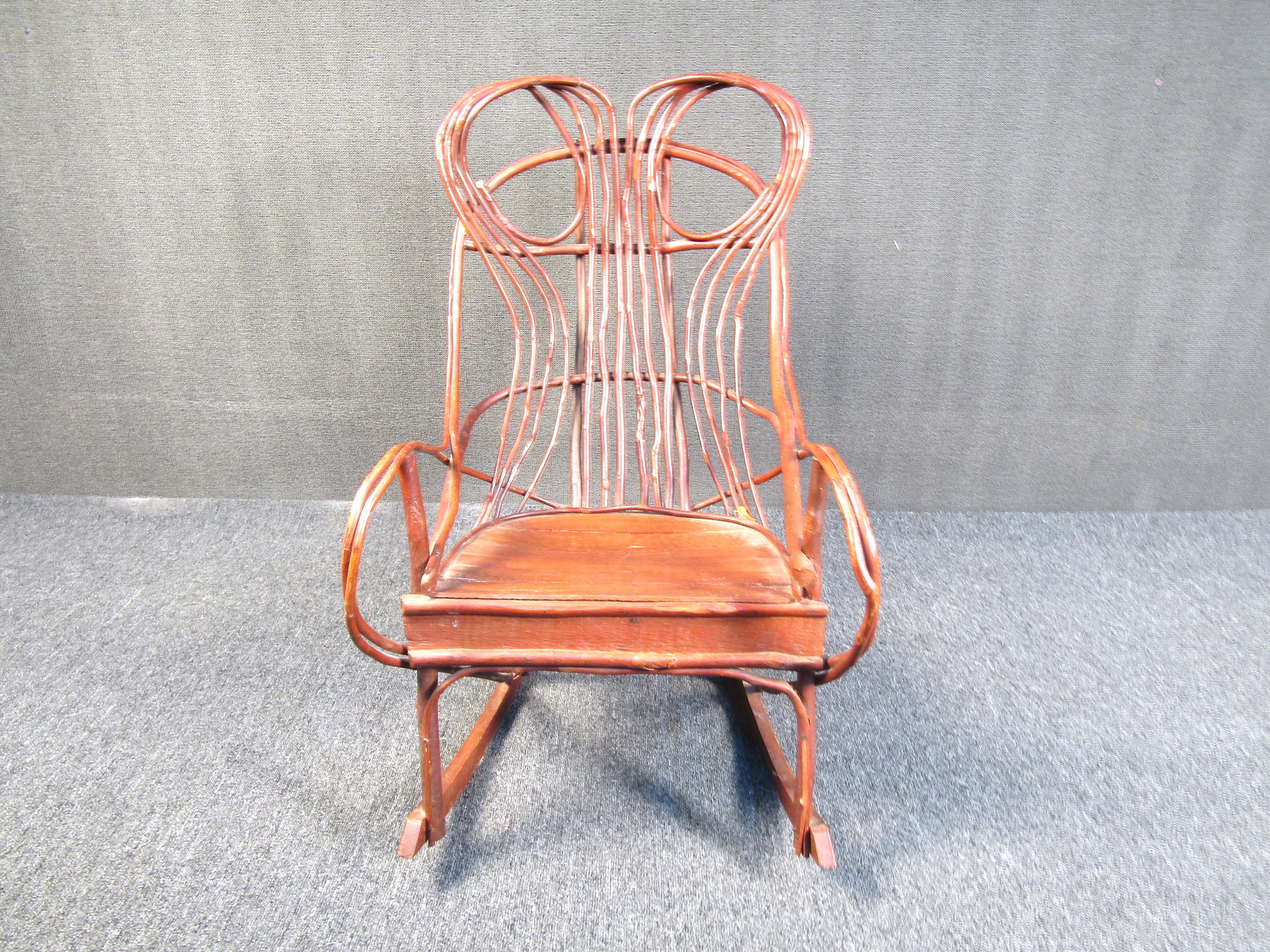 This incredibly unique rocking chair is made from intricately woven and fastened tree branches. it has a flat wood seat with the rest of the piece being made from actual non processed tree branches. This piece will add character and charm to any