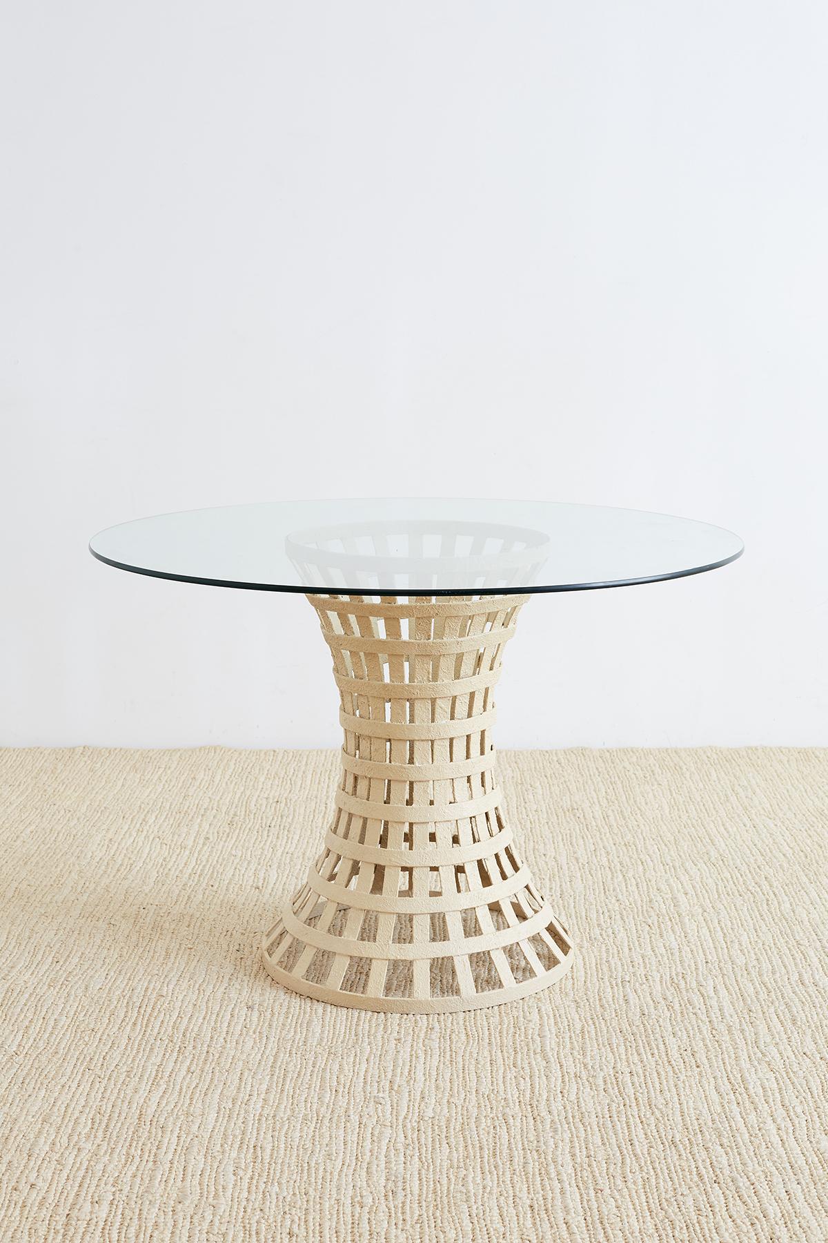 Unique Mid-Century Modern woven metal basket style breakfast or dining table. Features a painted metal base constructed from metal rings and slats in a waisted form topped with a pane of round glass. The base is heavy and solid finished with a thick
