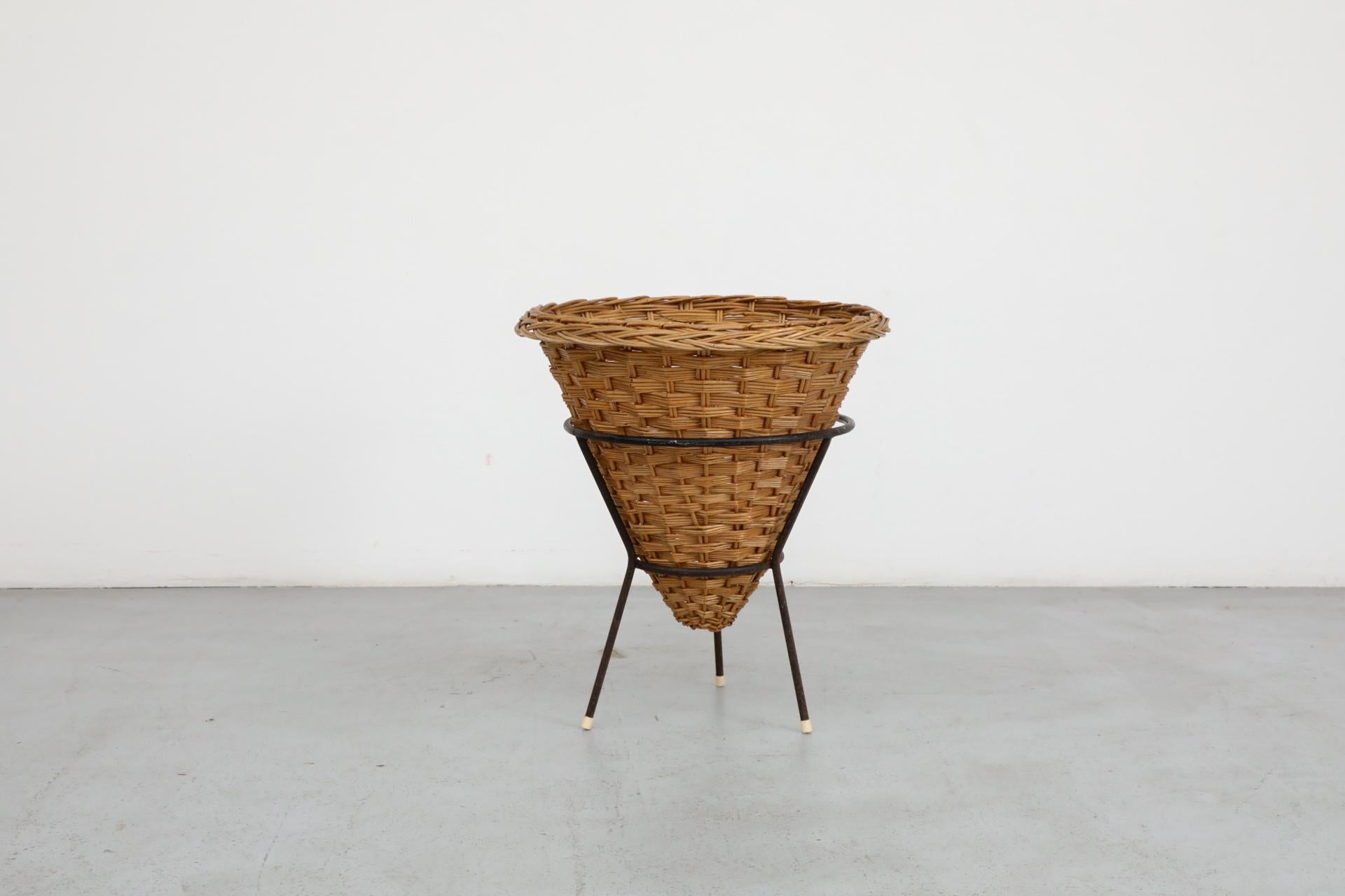 Smaltato Cestino in rattan intrecciato di metà secolo con base a treppiede in filo metallico smaltato nero in vendita