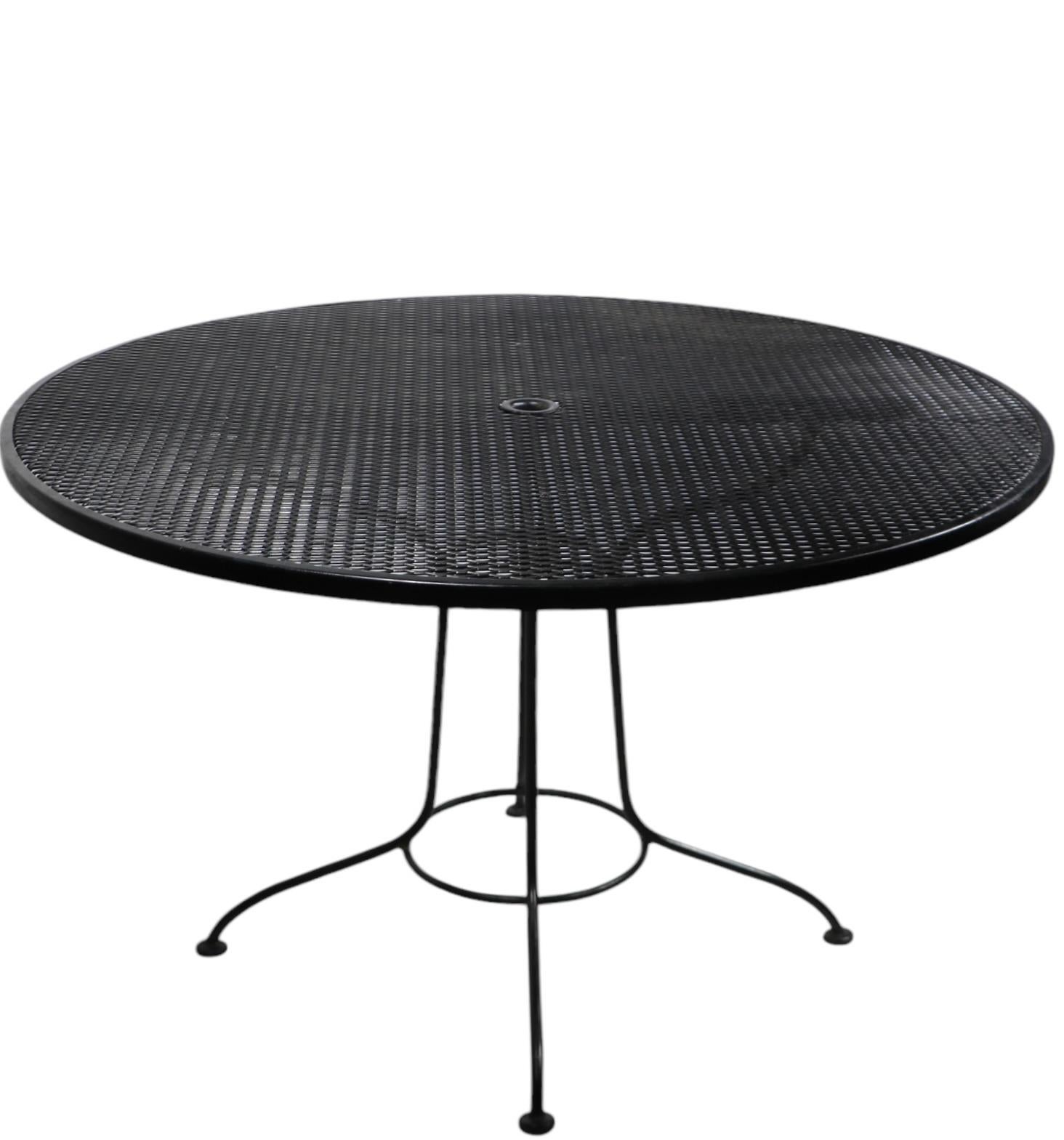 Nice, clean, ready to use vintage garden, patio, poolside dining table having a wrought iron base, with circular metal mesh top. Structurally sound and sturdy, showing only light cosmetic wear, normal and consistent with age, attributed  to the