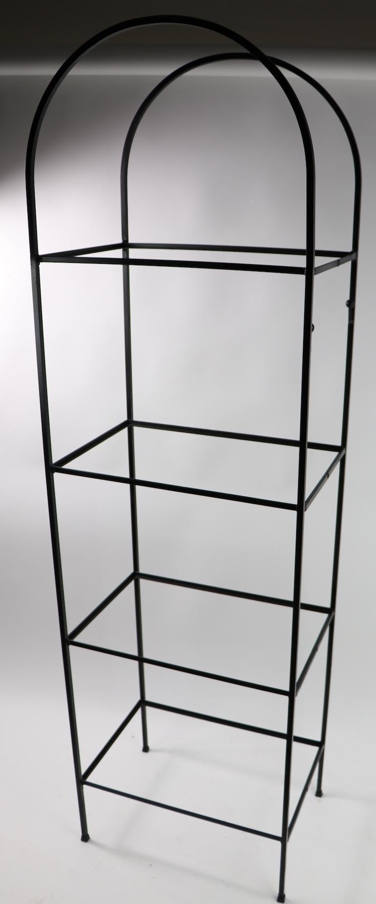 Arch top wrought iron shelf with plate glass shelves, attributed to Arthur Umanoff. Freestanding unit with four shelves, each 17 in apart. Great for display, storage etc. clean, ready to use.