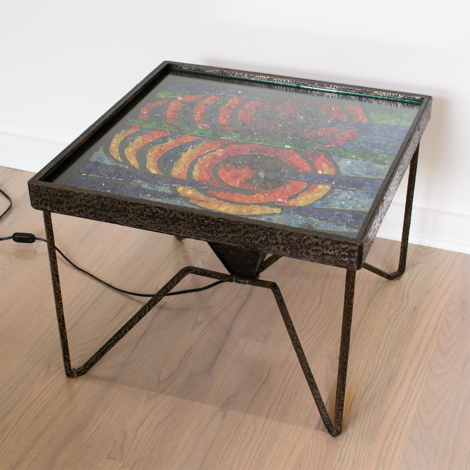 Here is an elegantly crafted one-of-a-kind 1960s coffee or side table. This cocktail table features an eye-catching geometric mosaic top with glass chunks encased in a textured wrought iron table base with spider-shaped legs. A glass tabletop