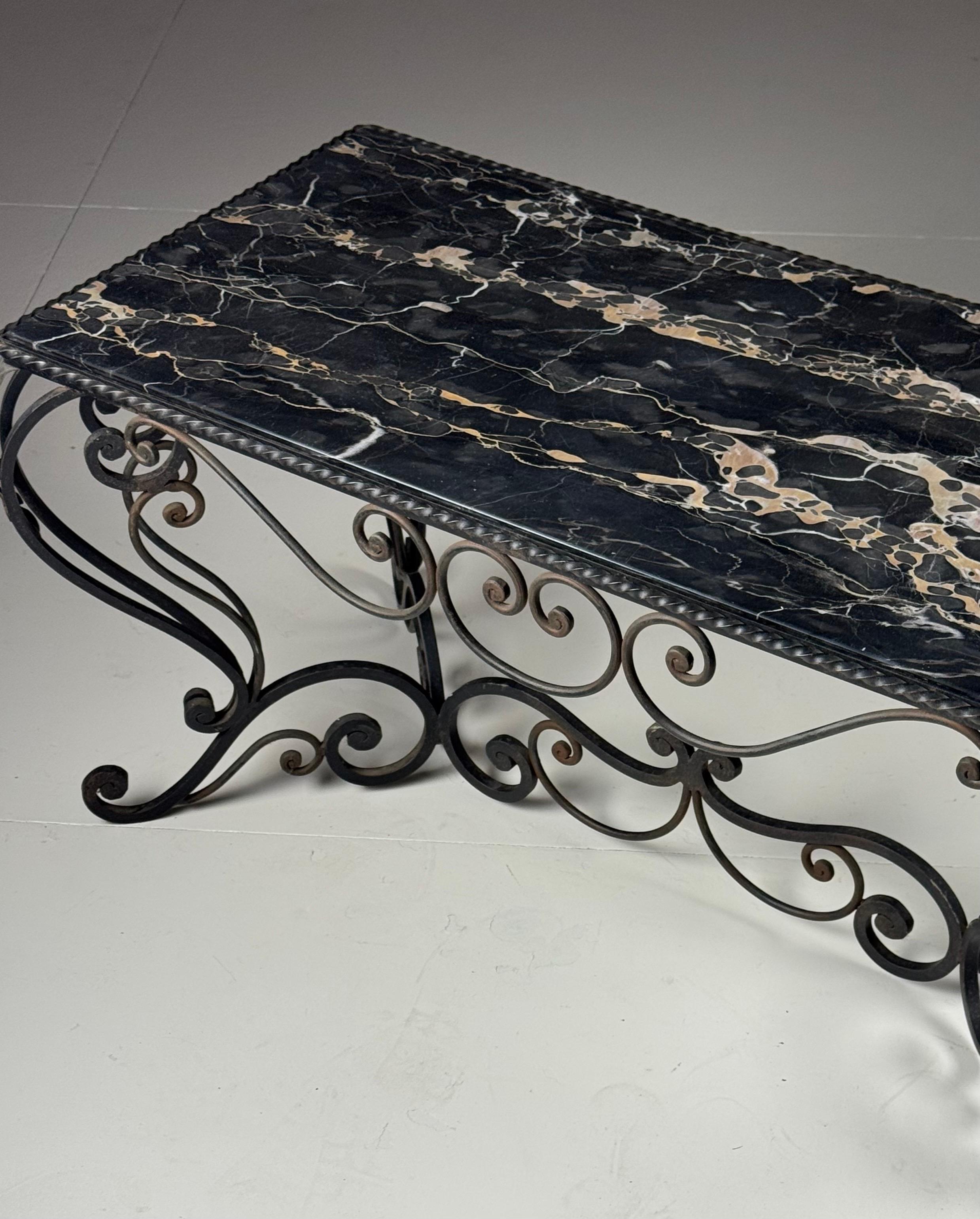 Mid-20th century wrought iron coffee table/side table. Elegant details with panels on the corners.

Black marble top with gold veins.

Dimensions: 107L x 55W x 49H