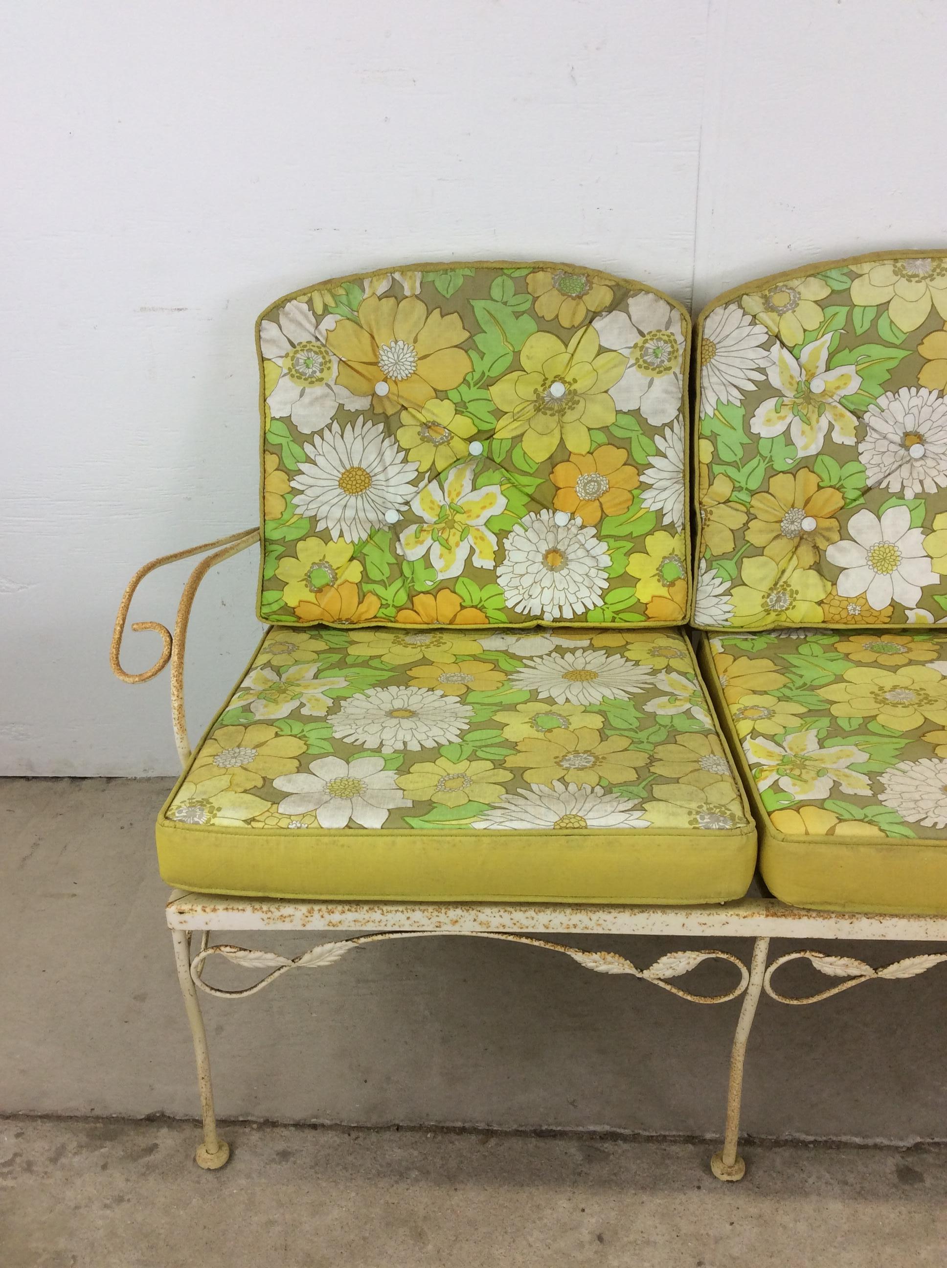 This mid century modern outdoor loveseat features wrought iron construction, fading yellow painted finish, vintage floral cushions with reversible yellow back side, and unique metal detailing throughout.  Matching lounge chair, swivel chair and