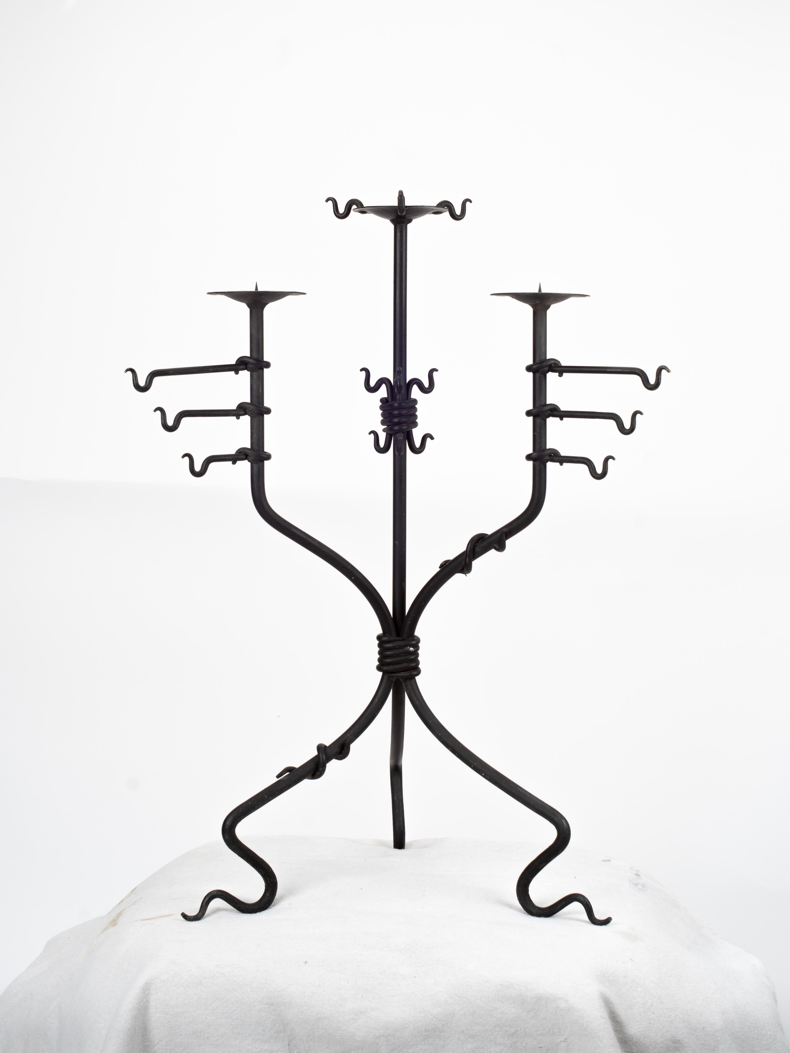 Straordinario candelabro italiano scultoreo in ferro piegato, proveniente dall'Italia. Questo candelabro ha un peso visivo notevole e le sue dimensioni e la sua marcata silhouette medievale attirano l'attenzione in qualsiasi spazio.

La base in