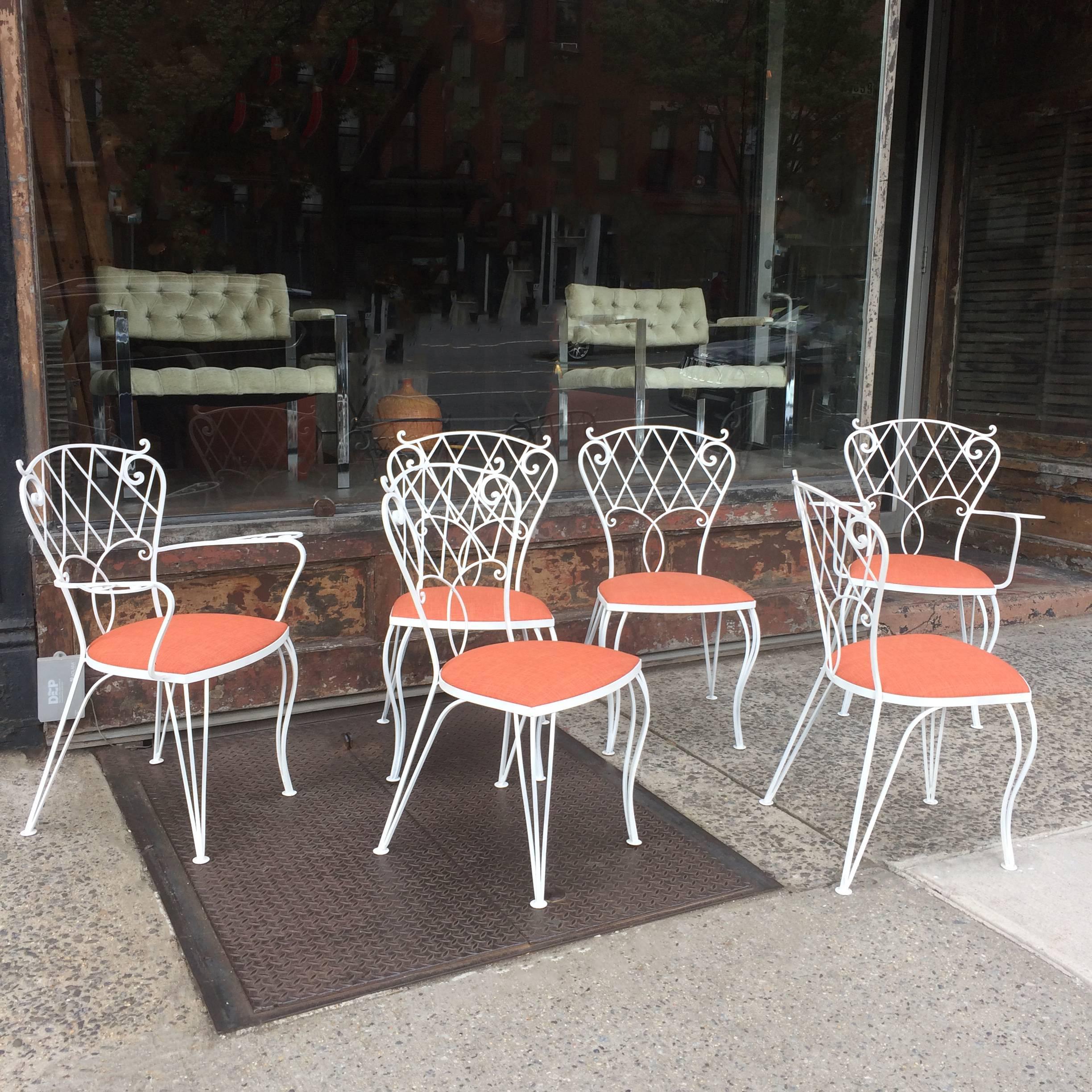 Set of six, mid century, patio, garden, outdoor, dining chairs feature scrolled, wrought iron frames that are newly painted with seats newly upholstered in durable outdoor fabric. The set includes four side chairs and two captain chairs that are