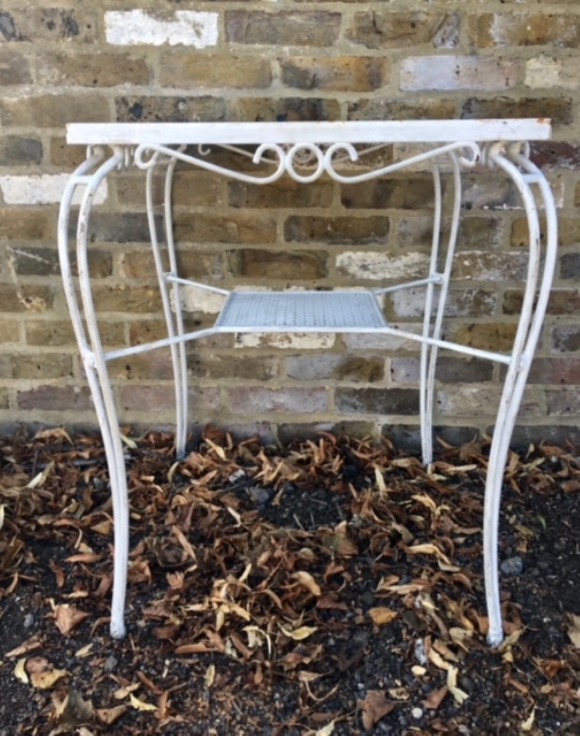 Mid-Century Wrought Iron White Garden Table, 1950s, French     

Lovely Mid Century French bistro garden table in the style of Mathieu Matégot, the table has a pressed steel top with intricate cut-out pattern. Square in shape with  a smaller shelf