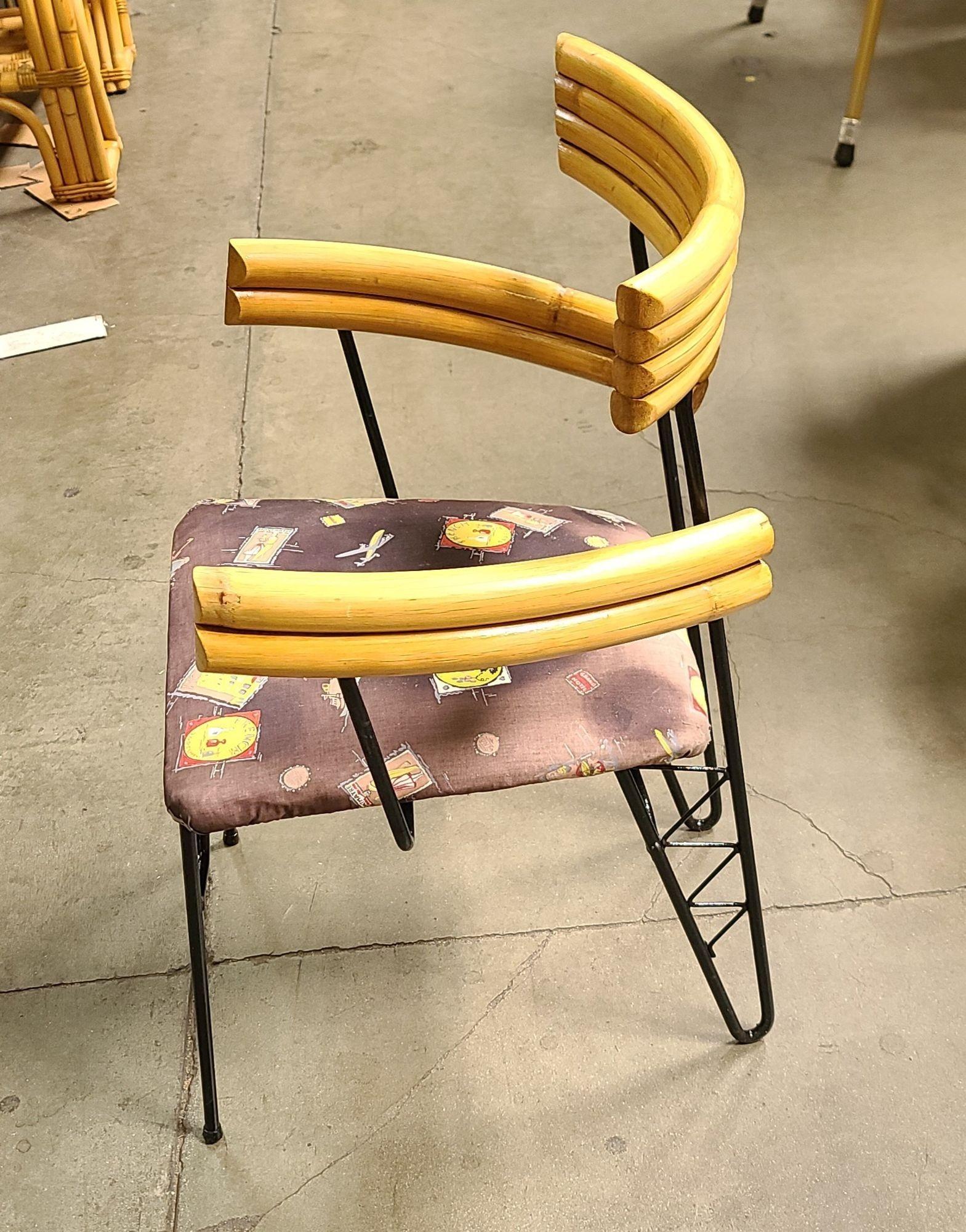 Circa 1950 Mid-Century wrought iron wire armchair with pole rattan arms, hairpin Legs, and original Googie fabric seat. Reminiscent of the chairs made famous by Shirley Ritz.