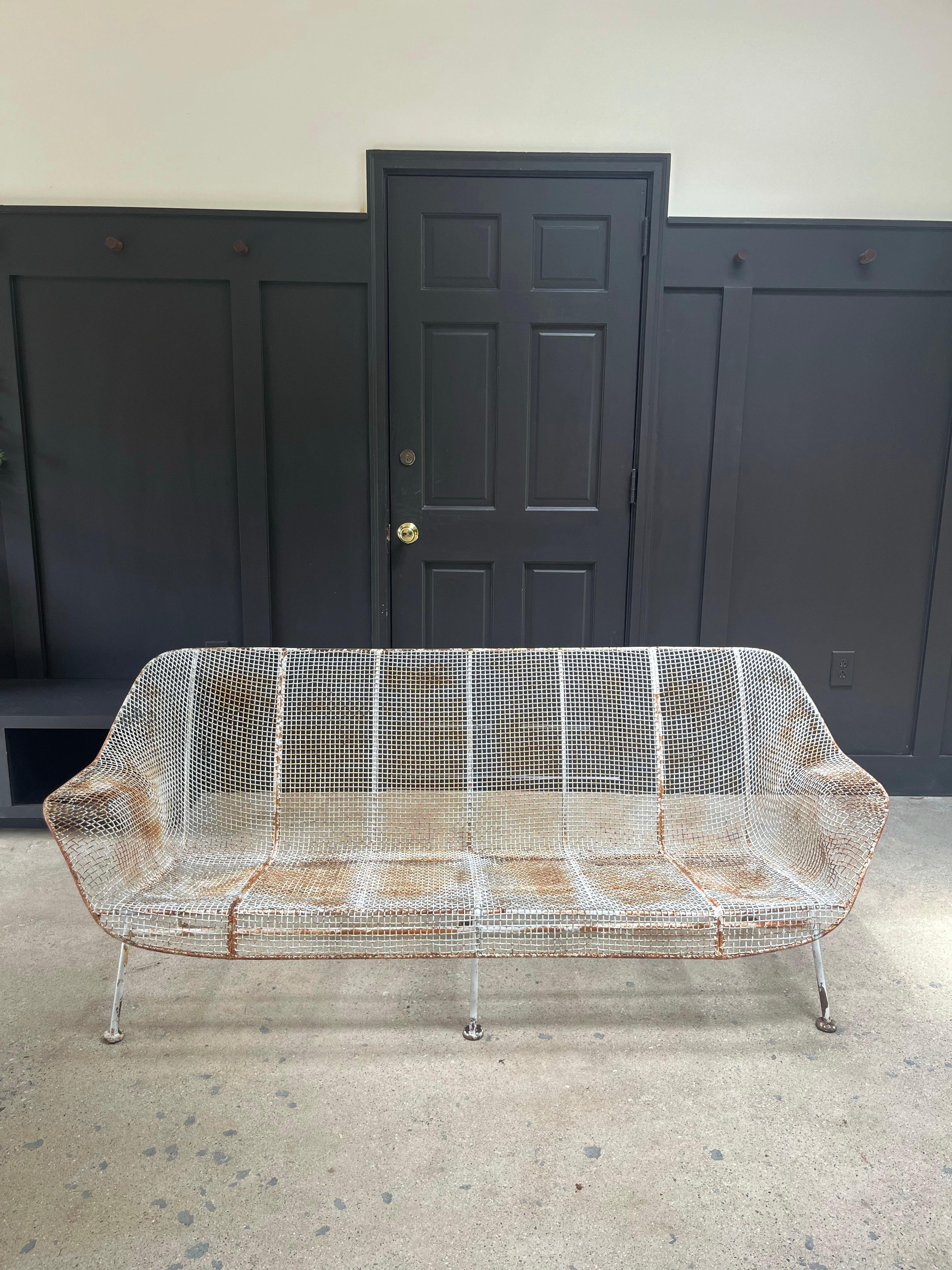 'Sculptura' wrought iron three seater sofa designed by Russell Woodard featuring a vintage patina. Circa 1950s.

78.5”W x 28”D x 27��”H x 13”SH x 19.5”Arm H