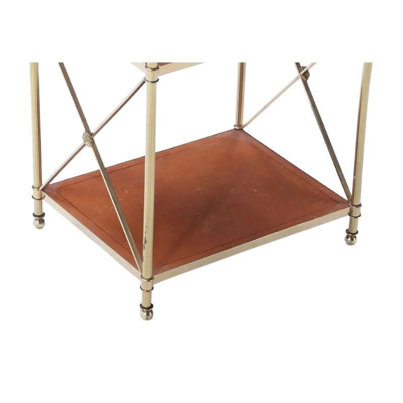 A Mid Century X form petite etagere with leather shelves.  The French brass and leather X form table is a fabulous Regency style side table with beautiful brass details, artichoke finials to the top corners and rosettes to the X center.  The warm