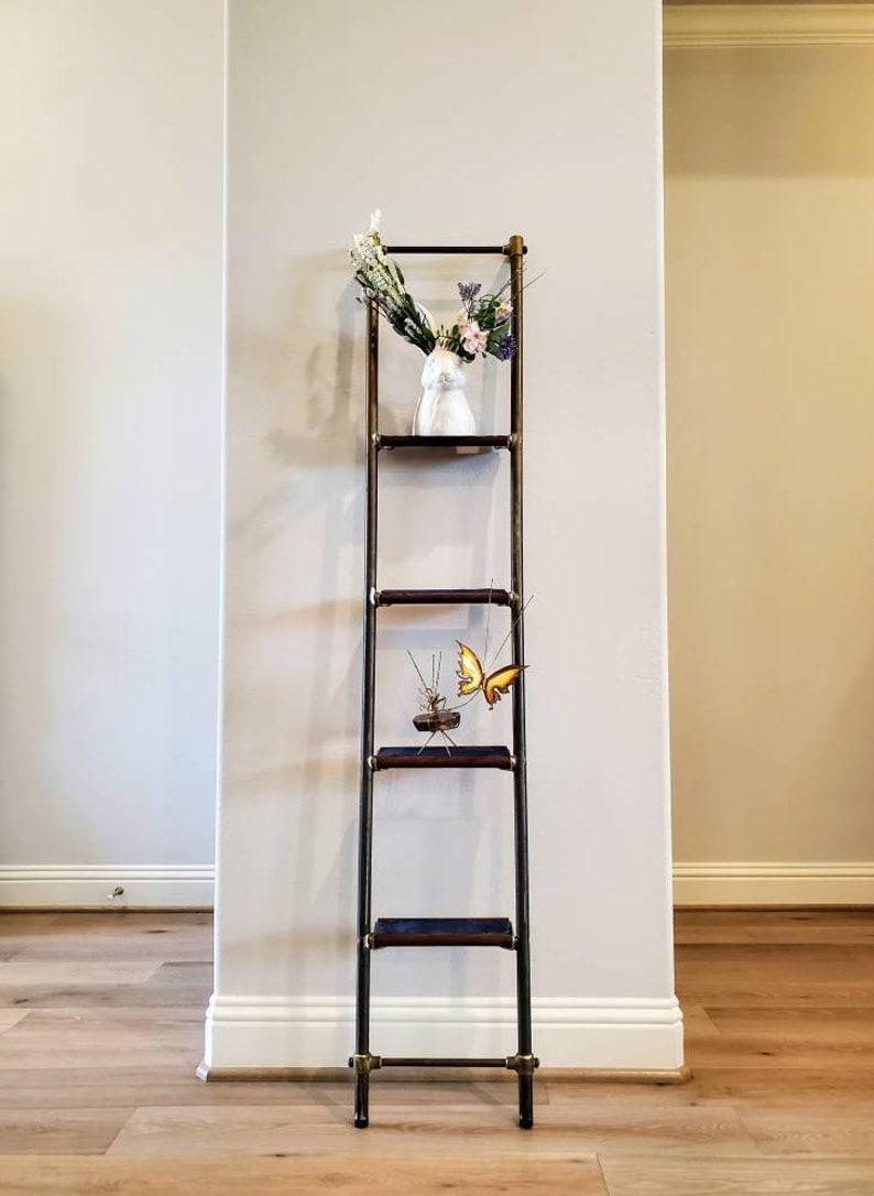 A rare luxurious mid-century yacht ladder with four collapsible folding solid mahogany wood steps, each fitted with rectangular inset blue rubber marine treads, patinated metal frame construction, two adjustable crossbar supports, brass hardware,