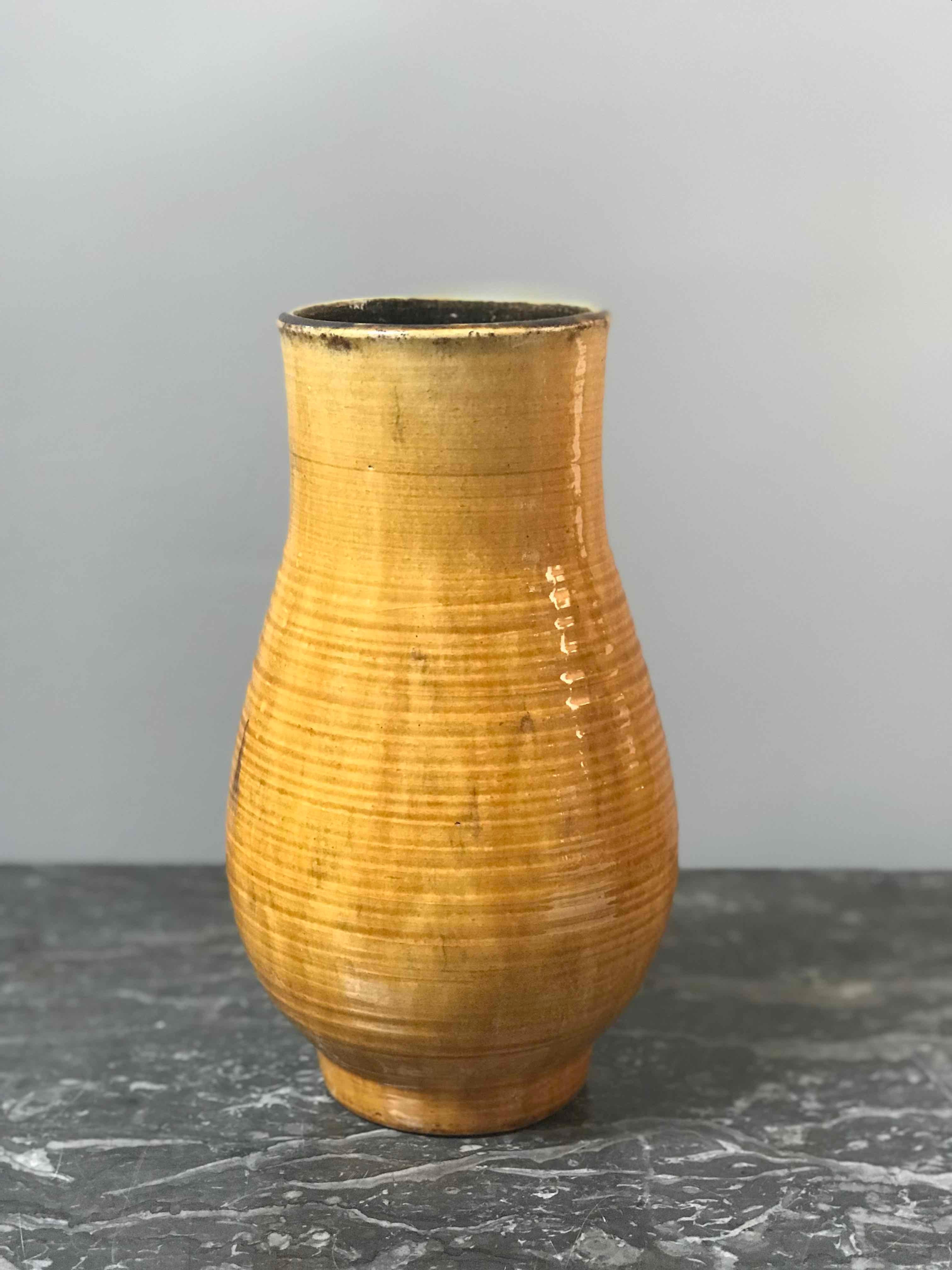 A yellow pottery vase. Originating in France, dating to 1940. 