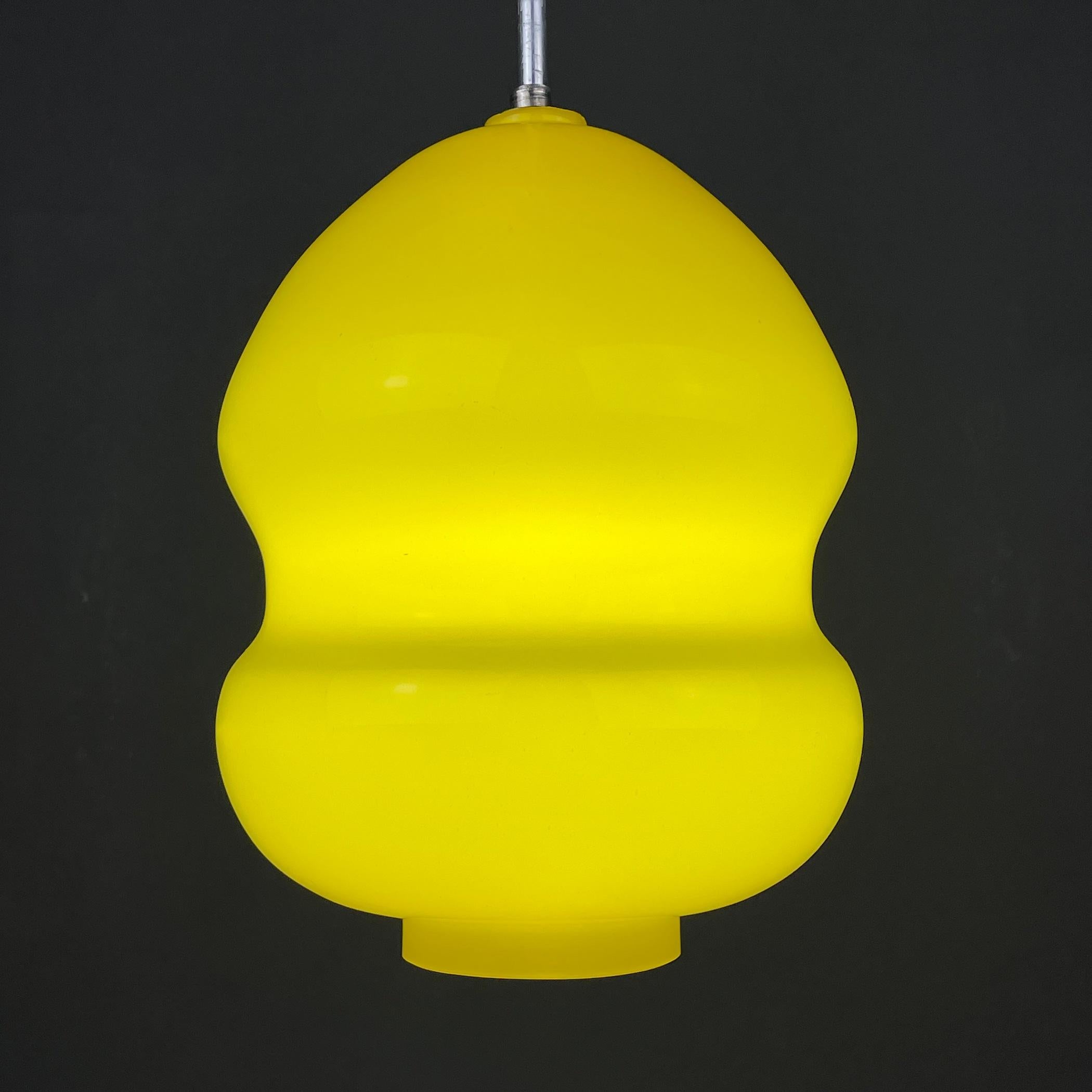 Vintage-Pendelleuchte aus gelbem Glas, hergestellt in Jugoslawien in den 1970er Jahren. Die schöne gelbe Farbe schafft Weichheit, Gemütlichkeit und Komfort. Daher ist es für Kinderzimmer, Schlafzimmer und Wohnzimmer geeignet. Benötigt eine Standard