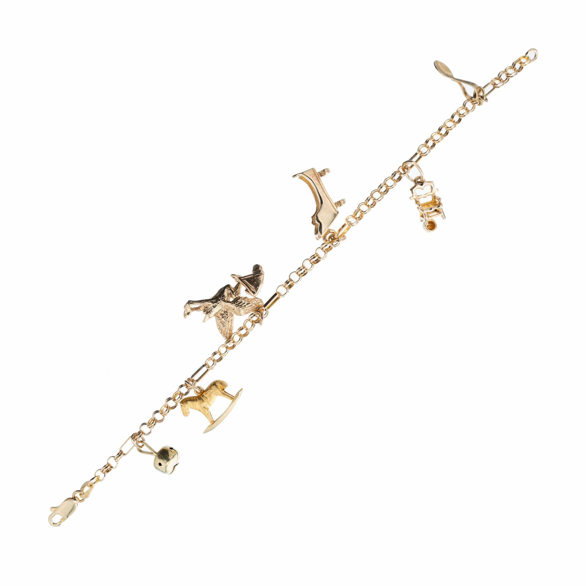 Mid-Century 1960's 14k yellow gold baby themed charm bracelet with baby rattle, rocking horse, stork, bassinet, potty seat and spoon charms. Secure lobster catch. 7 inches in length. 

14k yellow gold 
Stamped: 14k
15.9 grams
Bracelet: 7