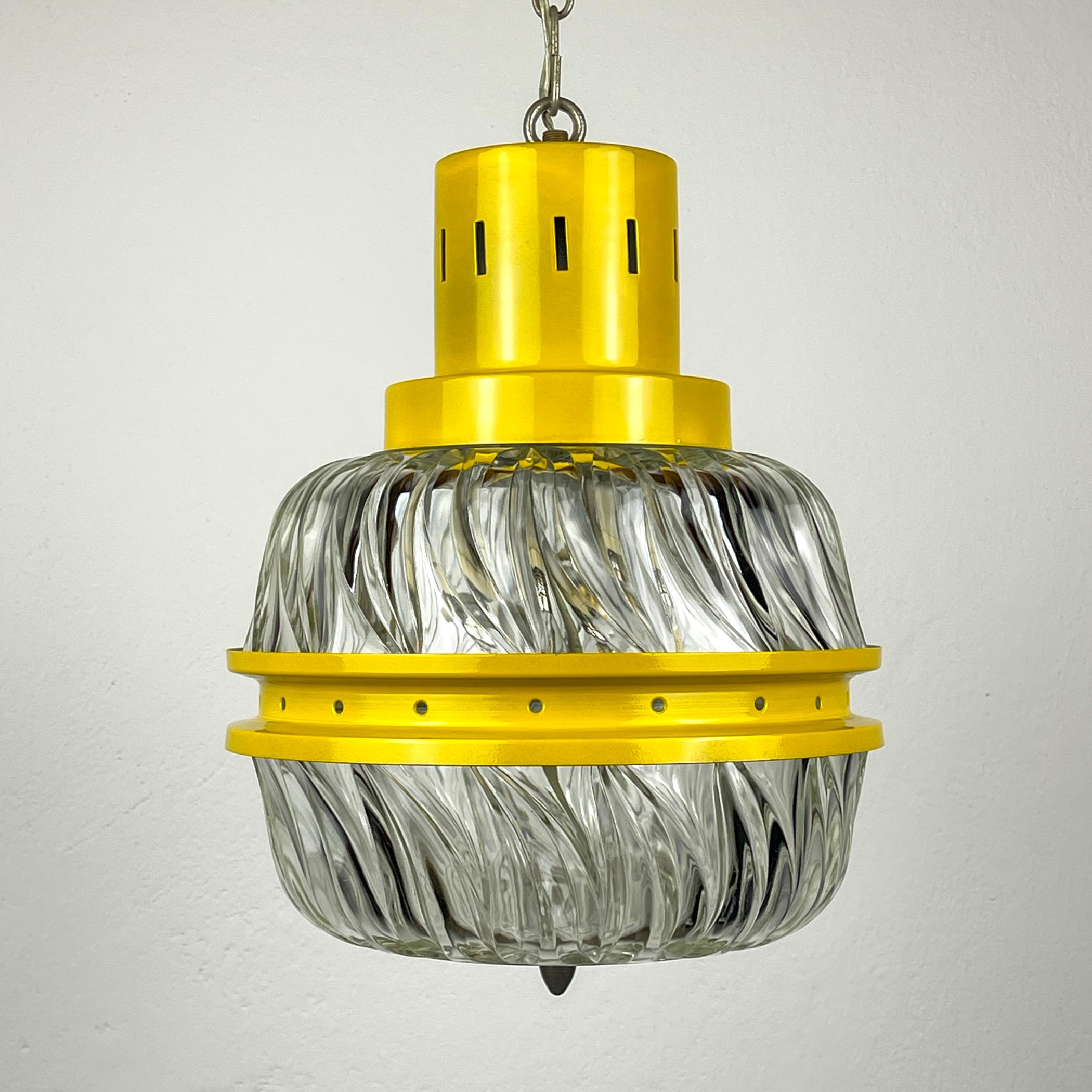 

Amazing mid-century chandelier made in Italy in the 1960s.
Thick glass decorated with an ornament is framed by a yellow metal plate. Perfect for your home, give it the atmosphere of Italy in the middle of the last century.

Very good vintage