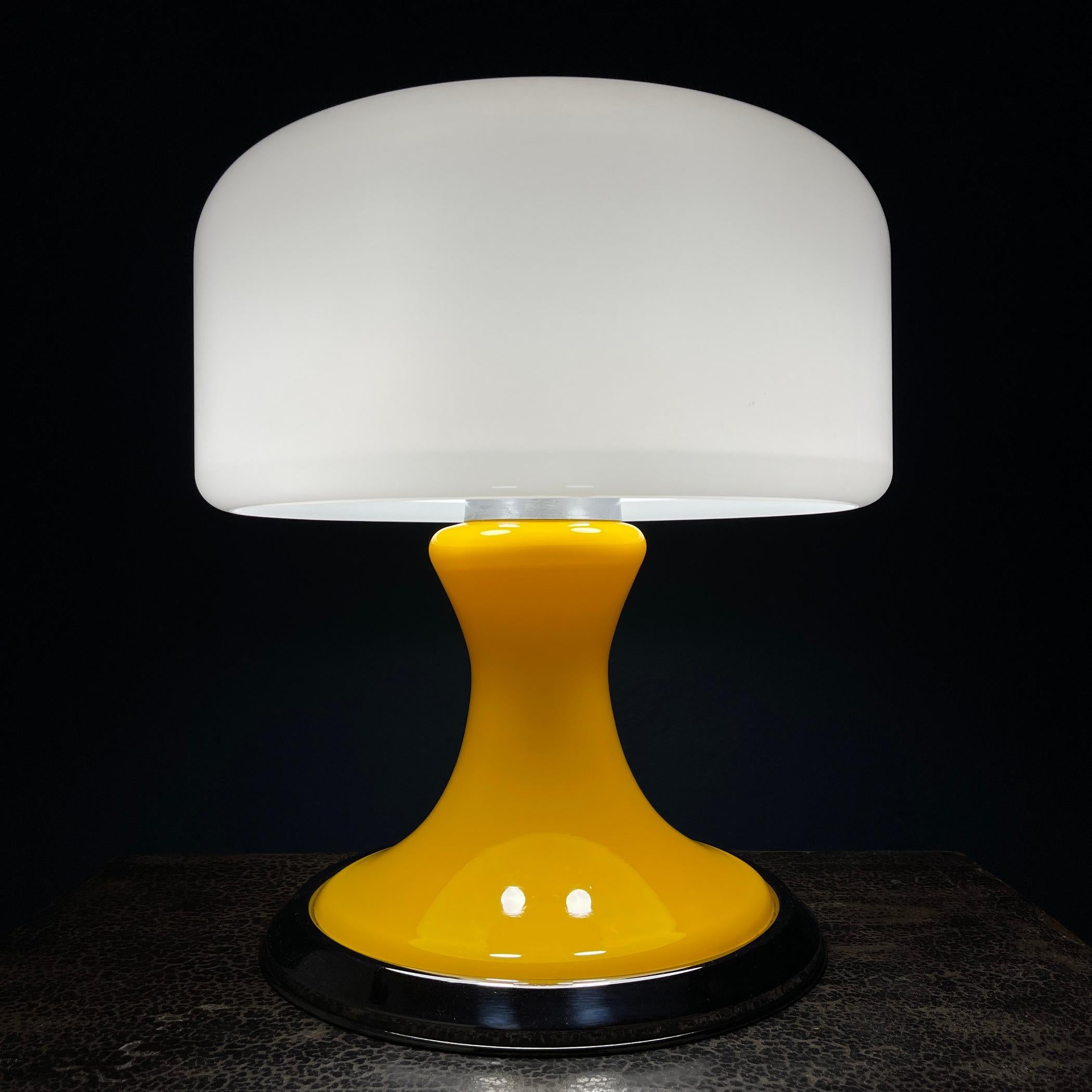 Introduce a touch of retro charm to your space with this mid-century Italian large table lamp from the 1970s. Its white plastic top and yellow glass base embody the iconic Space Age design aesthetic, 70s. Equipped with three E14 bulbs, this lamp