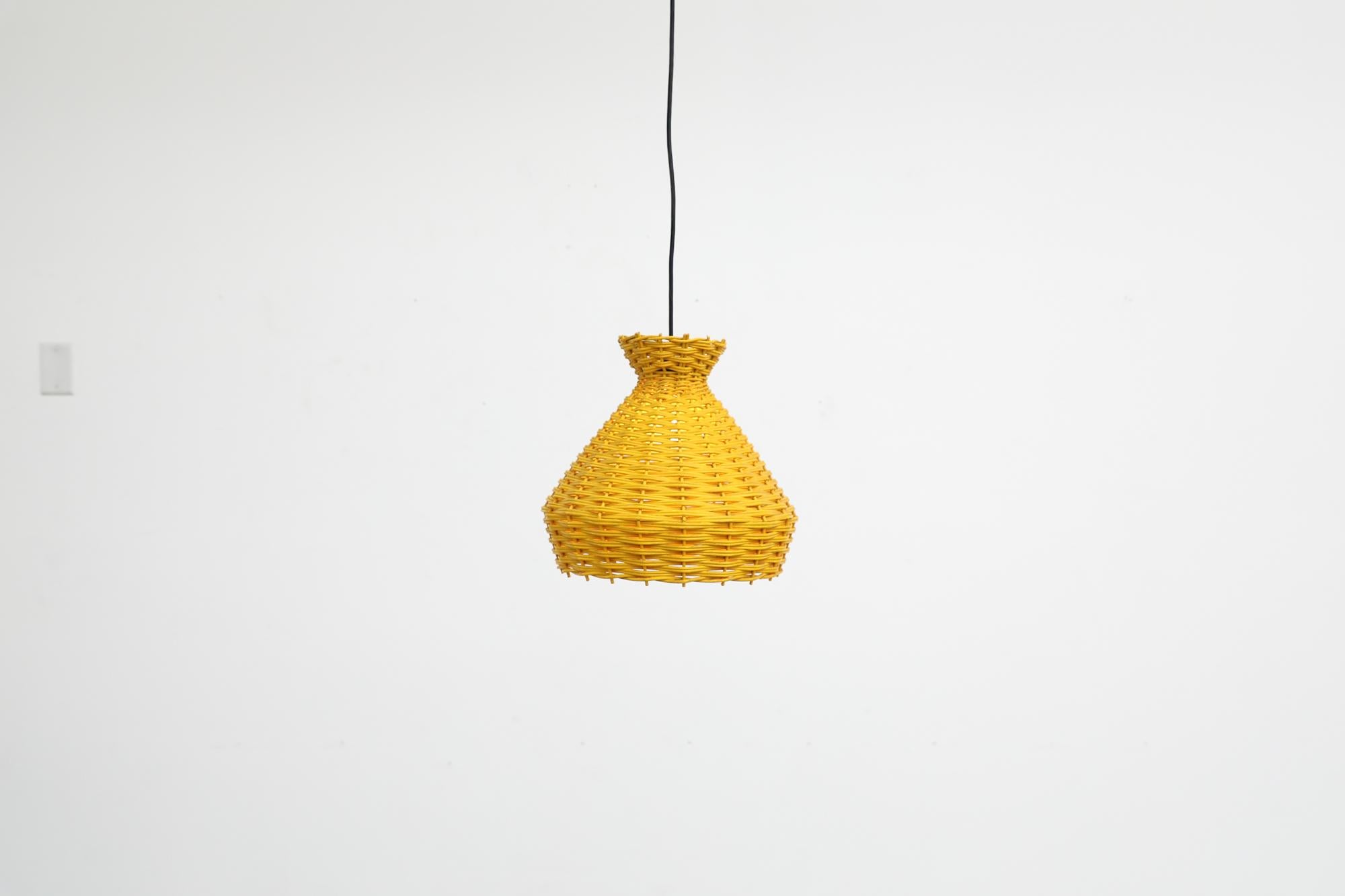 Beautiful, Mid Century 1960's yellow lacquered woven rattan pendant lamp with black power cord.  Striking shape, reminiscent of the designs of Tom Dixon. In good original condition with normal wear for its age and use. .
