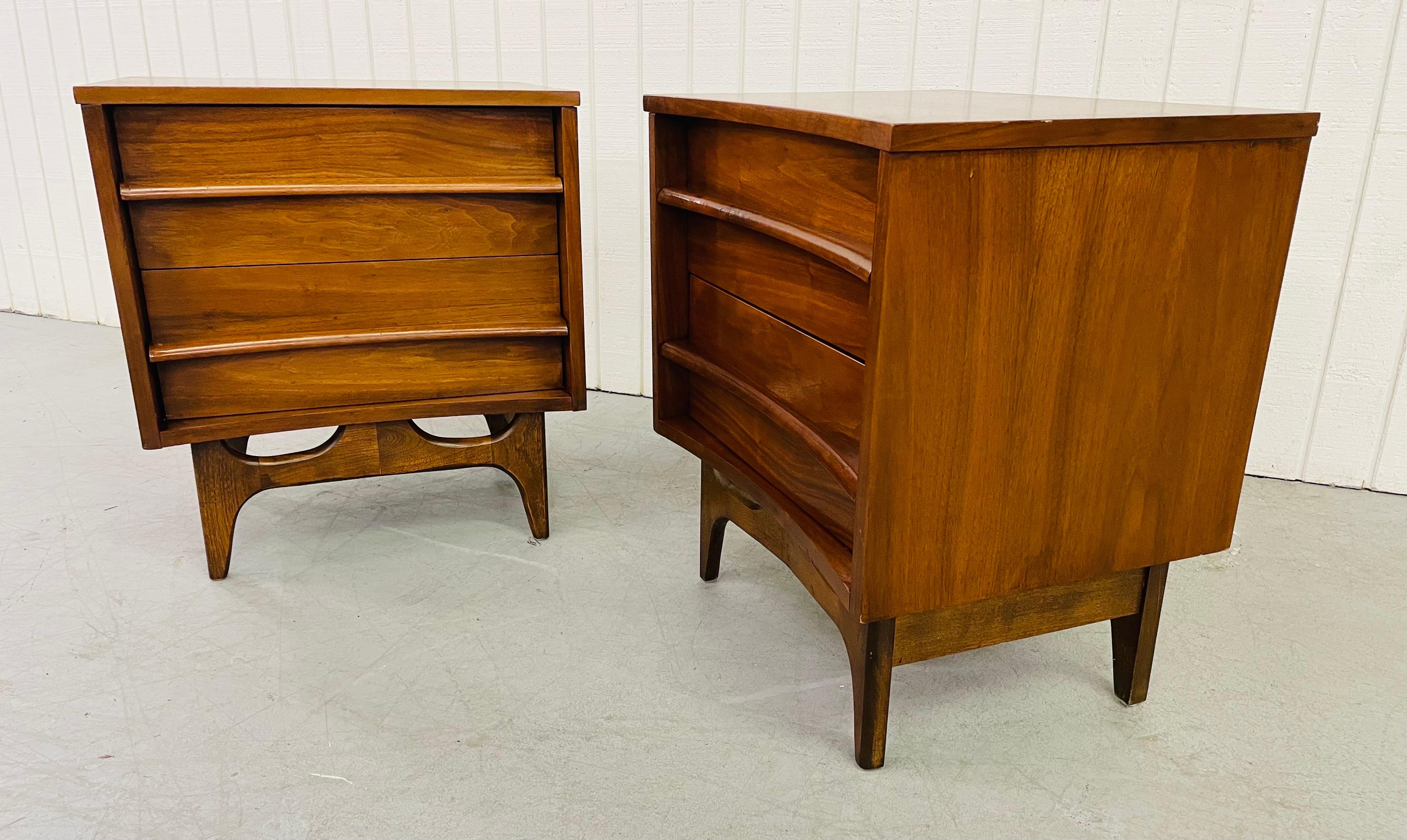 This listing is for a pair of mid-century young MFG walnut nightstands. Featuring a curved front, two drawers for storage with wood pulls, exceptionally designed legs, and beautiful walnut finish.