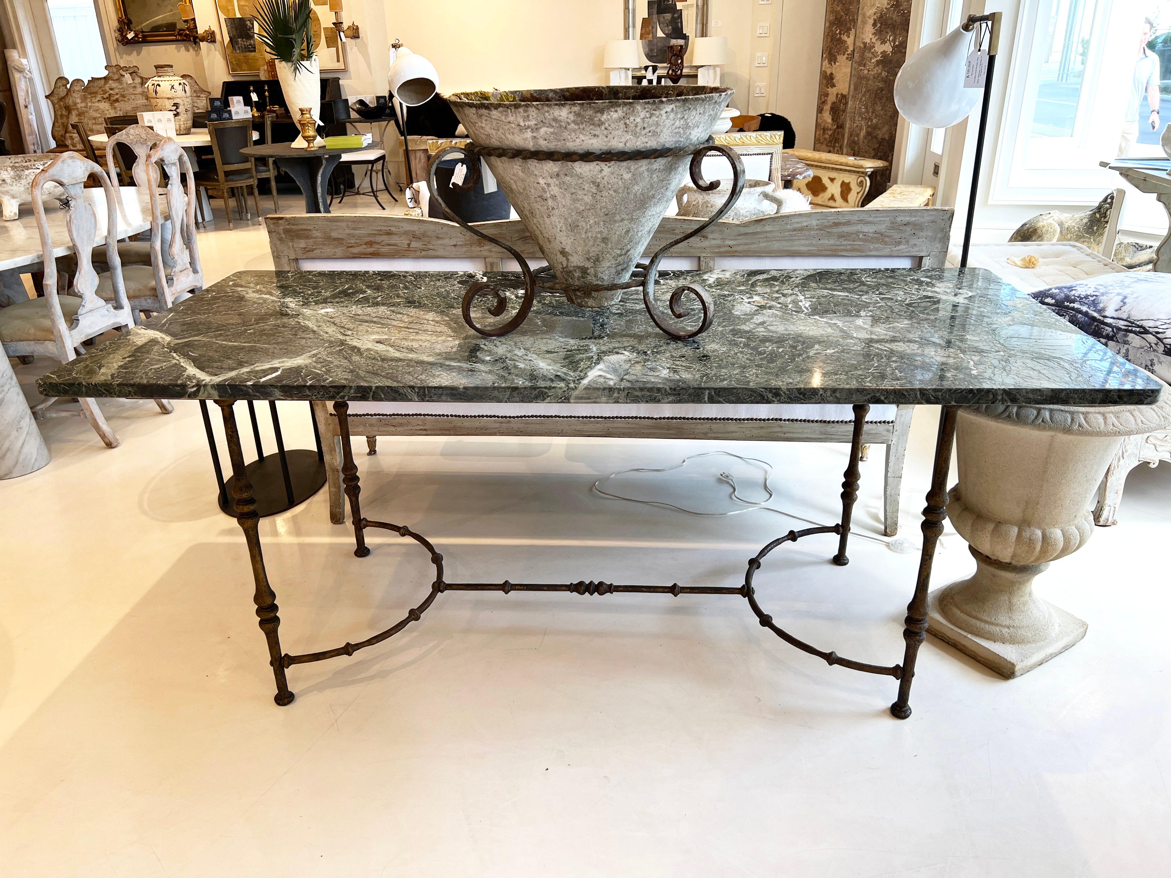 This Maison Jansen mid-century iron and stone table embodies the refined elegance and craftsmanship of the renowned Parisian design firm. It features a wrought iron base with neoclassical or modernist influences. The design includes curved, tapered