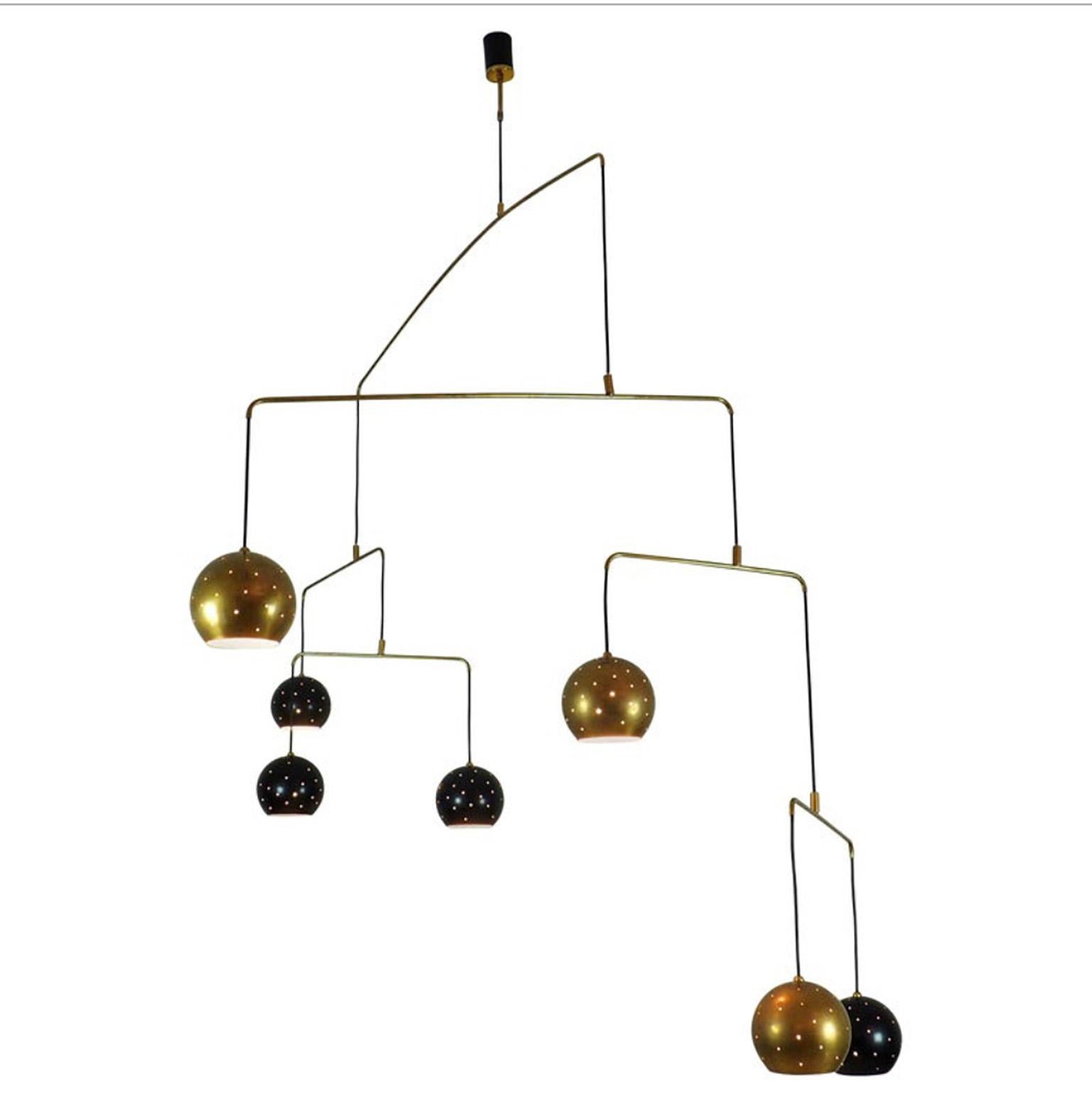 Original Italian brass mobile chandelier manufactured in a very small handcraft production in Milano, 20th century
Large, magic and poetical mobile chandelier with brass and black suspending spheres, it can moves with the flow of air.
Wholly in