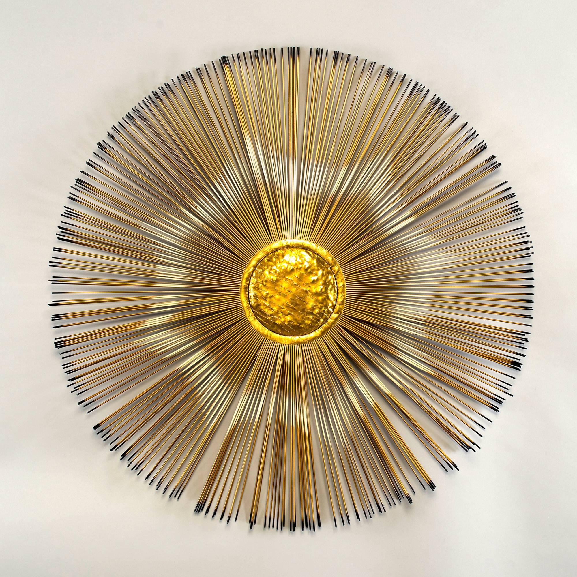 Brass and metal wall sculpture in form of sunburst with bright brass centre and slender metal rays with black tips, circa 1970s. We believe this is a Curtis Jere piece, but found no marks.