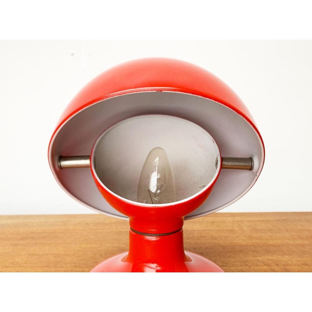 Petite lampe de table space age du fabricant italien Flos d'après un design d'AGE et Tobia Scarpa des années 1960.

Un design ludique mais très fonctionnel. La lampe se compose d'une base avec un pied en forme de plaque et un réflecteur, et d'un