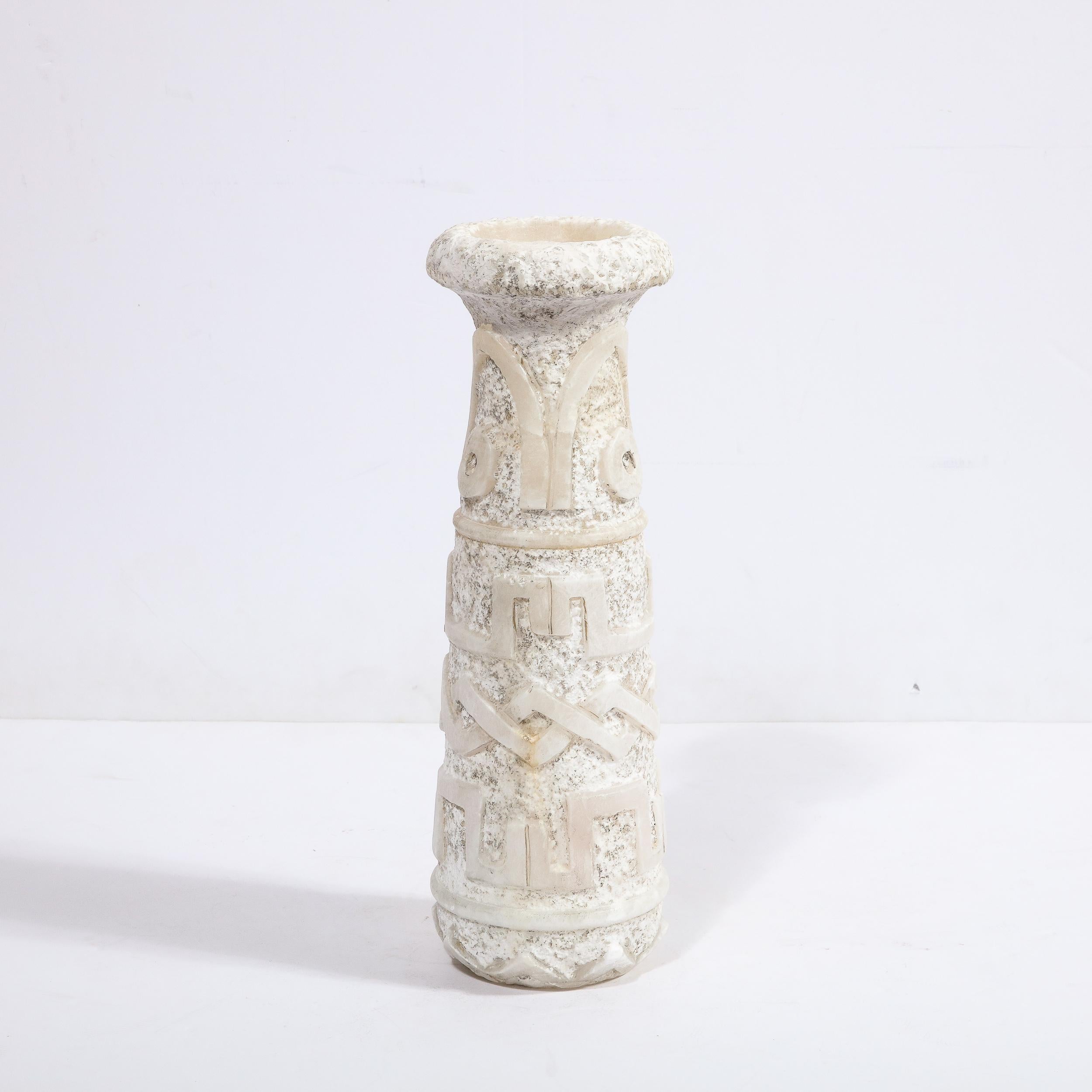 This sophisticated Mid Century Modern primitivist vase was realized in France circa 1950. It features a cylindrical body that tapers towards the top with a flared mouth that cantilevers over the body of the piece- in a beautiful white exotic marble.