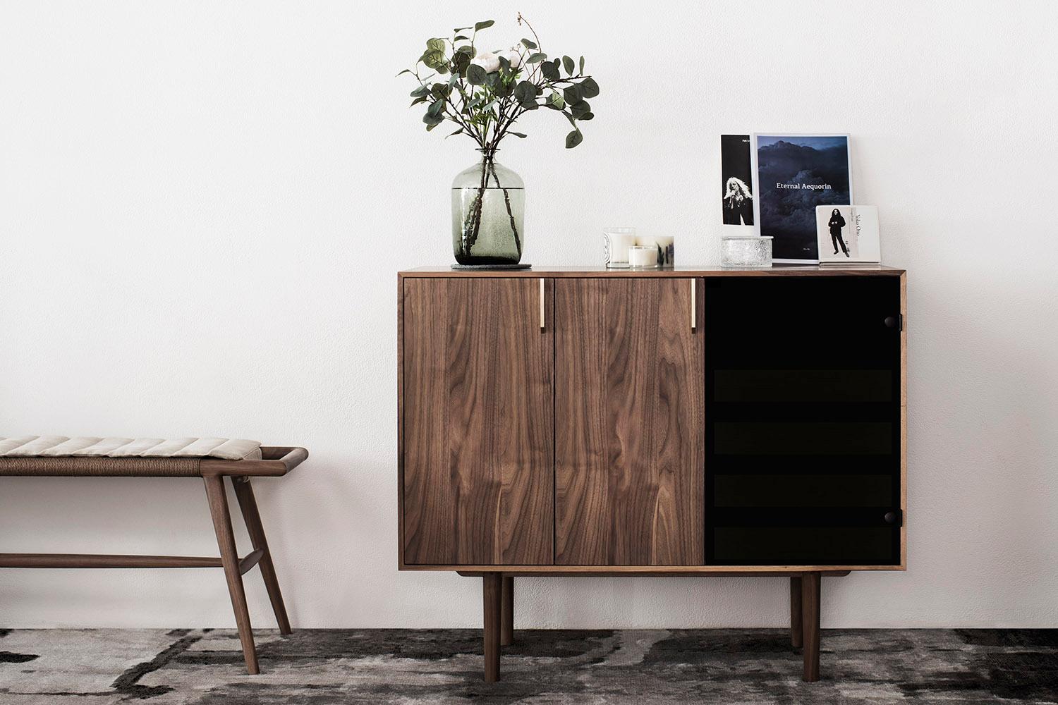 12H's Triptych cabinet is a beautifully designed storage solution, perfect for those who appreciate thoughtful craftsmanship. Made with enduring FAS-grade American walnut wood and brushed brass handles. Its facade is separated into three panels;