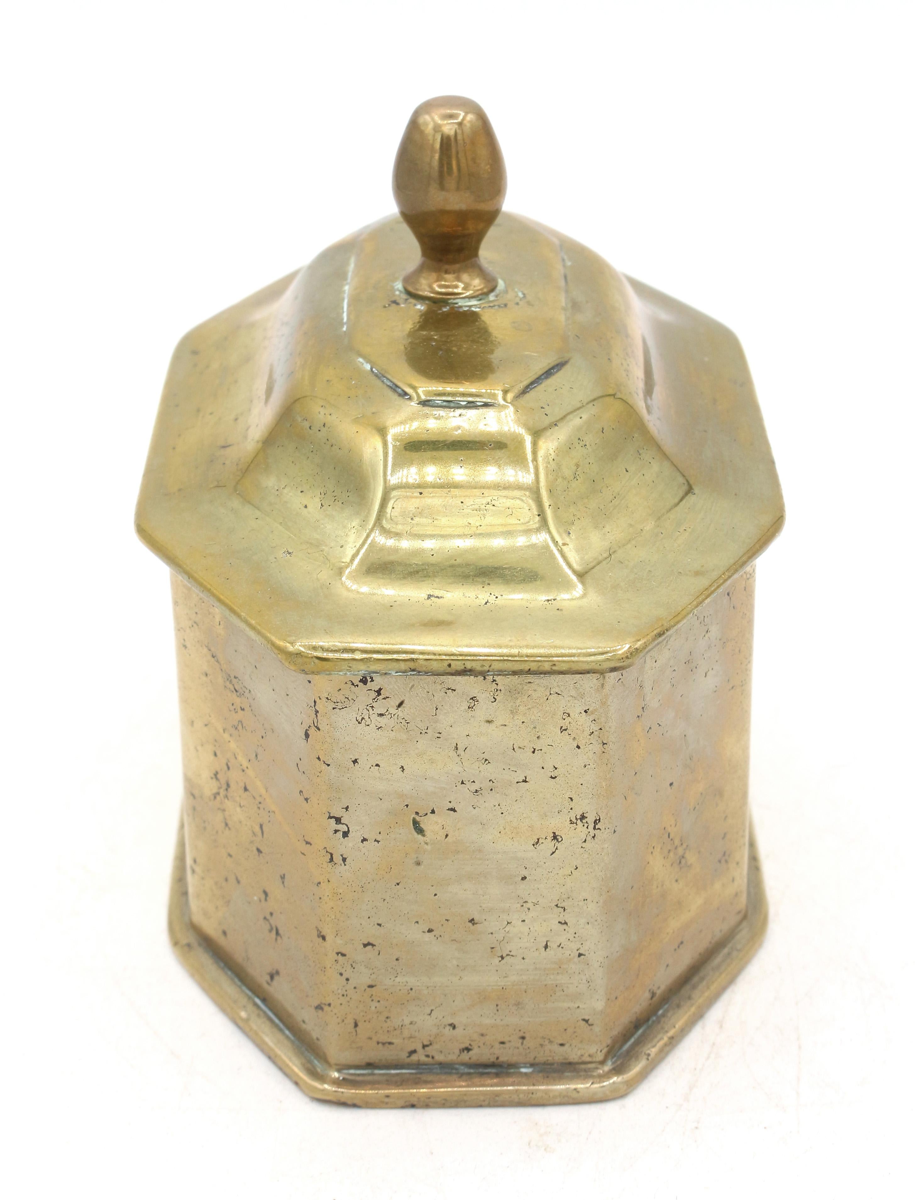 Tabatière en laiton moulé du milieu du XVIIIe siècle, anglaise. Huit côtés avec un couvercle conforme avec un embout métallique en forme de cloche.
5 1/8