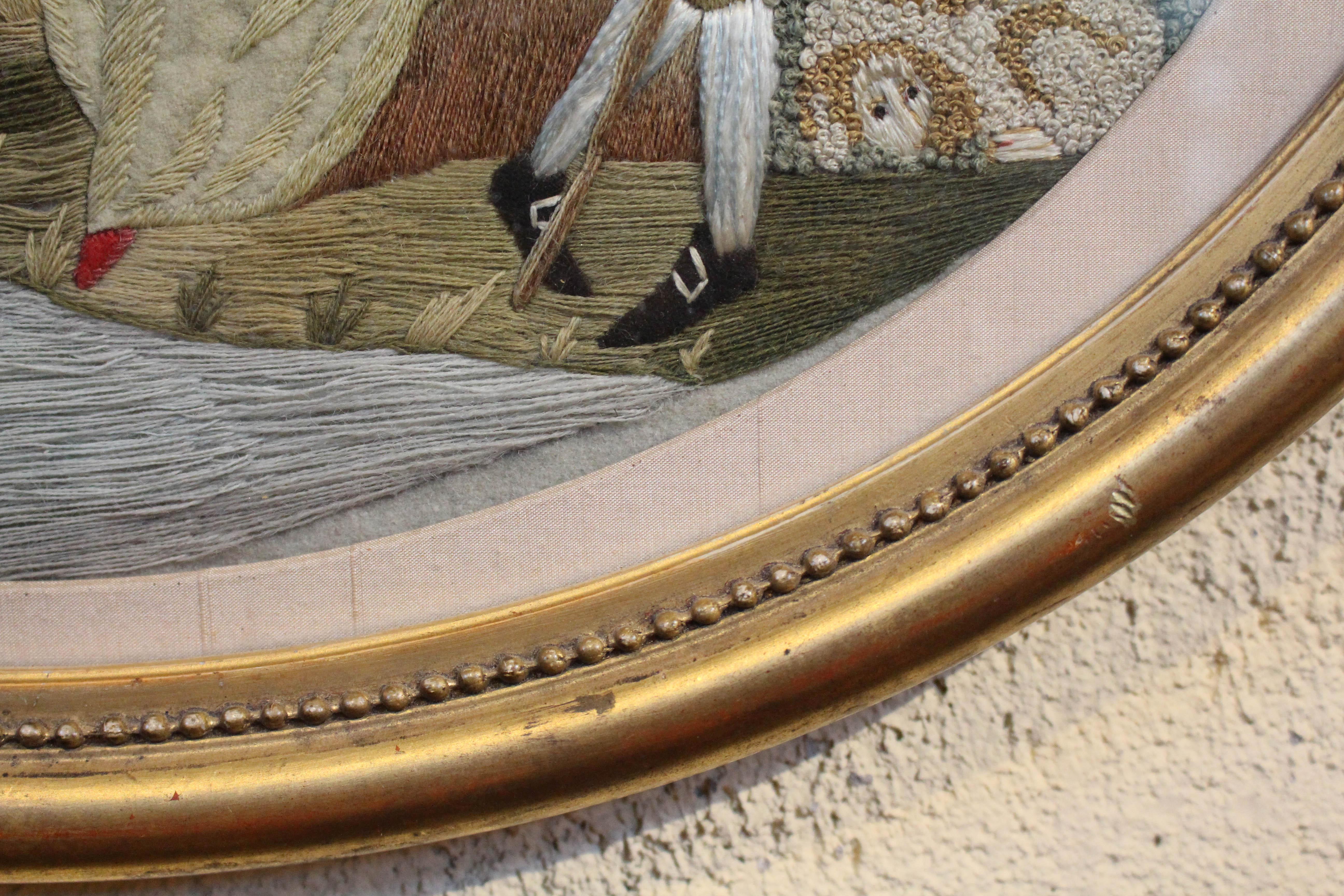 Mid-late 18th century silk & stumpwork picture, English. A fine Georgian period piece featuring a shepherd & shepherdess under a tree with a house in the background. Oval gilt & beaded border frame. The scene employs multiple techniques & materials