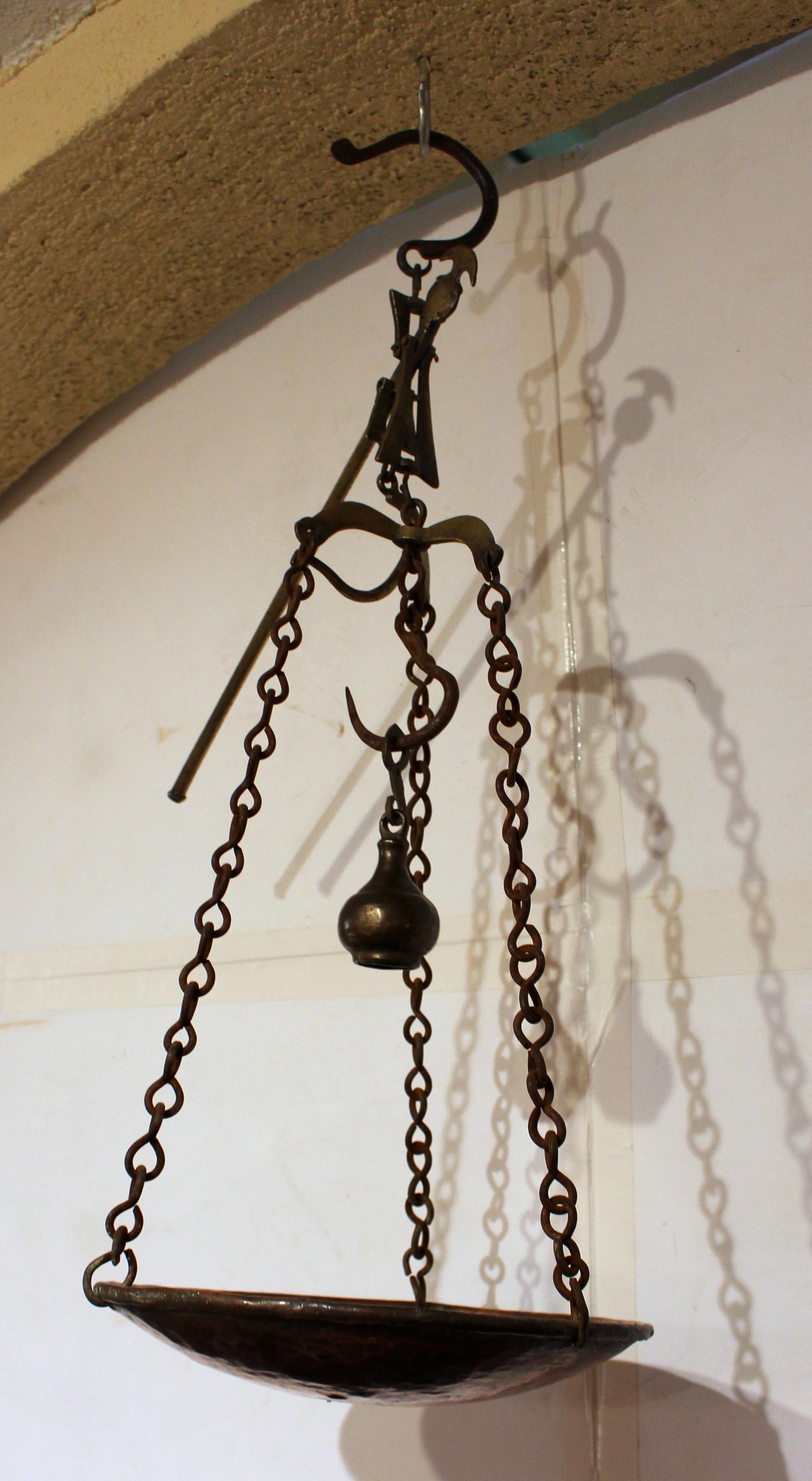 Mid-late 19th century brass, copper & iron hanging scale, European. For a shop, the weight hangs from the central lower hook while the item is added to the copper hanging pan until the brass bar is perpendicular to the scale for the correct amount.