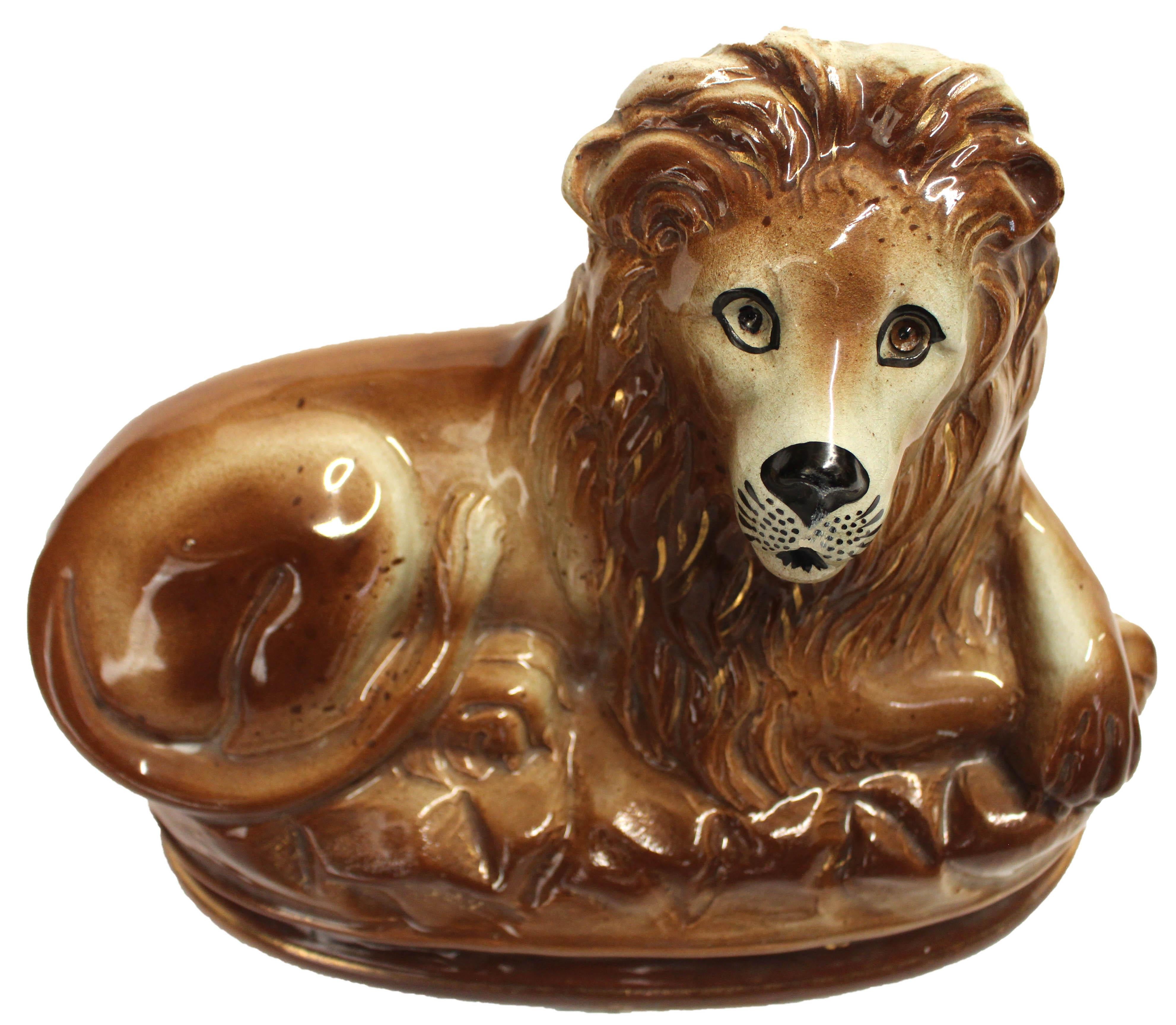Mid-late 19th century Pair of Bo'ness Staffordshire Lions, Scottish. Tawny brown recumbant hearth lions. Particularly nice integral bases with gilt highlights. Each lacks one eye. 12.25