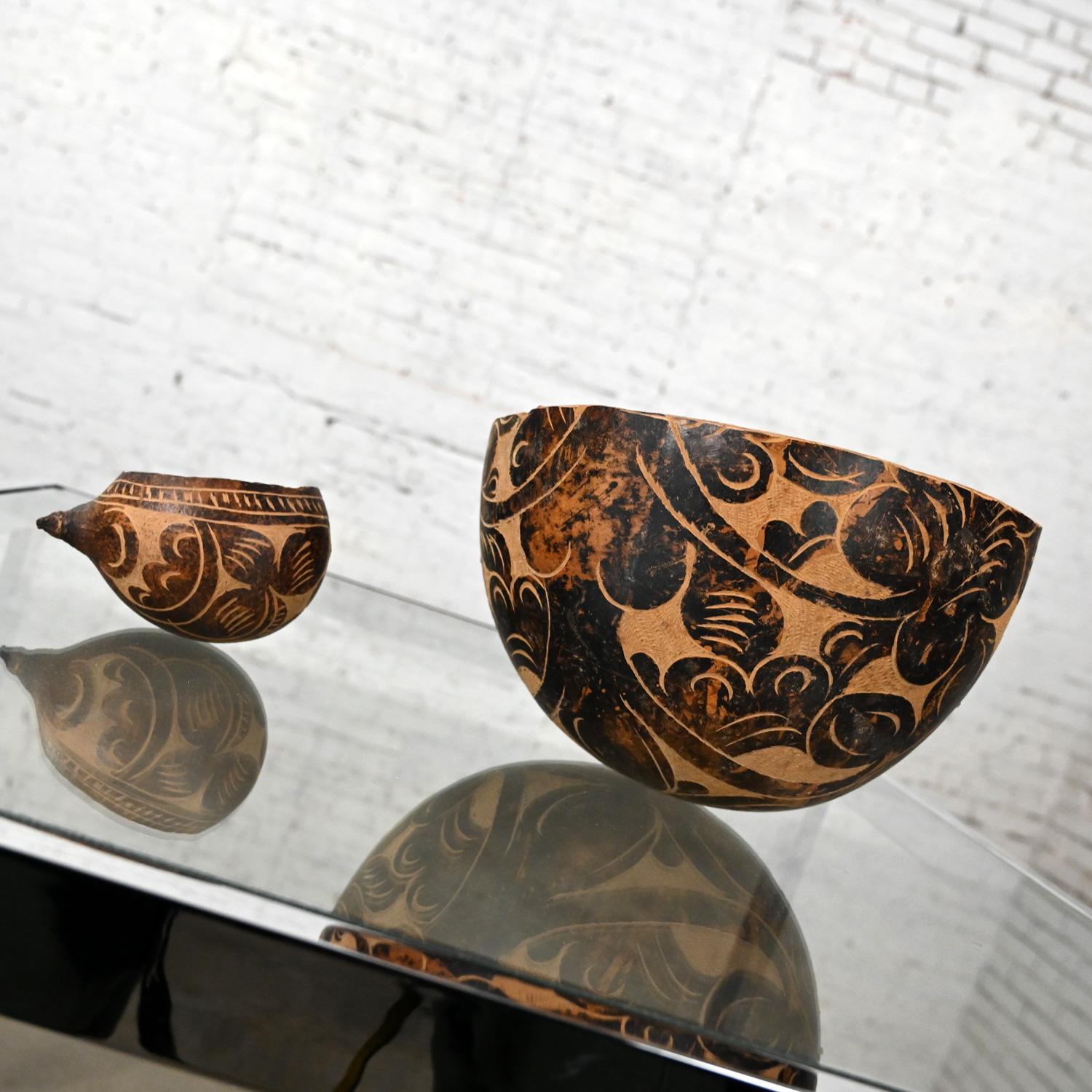Stunning Mid to Late 20th Century South American Tribal gourd bowls with hand carved floral details, a pair. Beautiful condition, keeping in mind that these are vintage and not new so will have signs of use and wear. Please see photos and zoom in