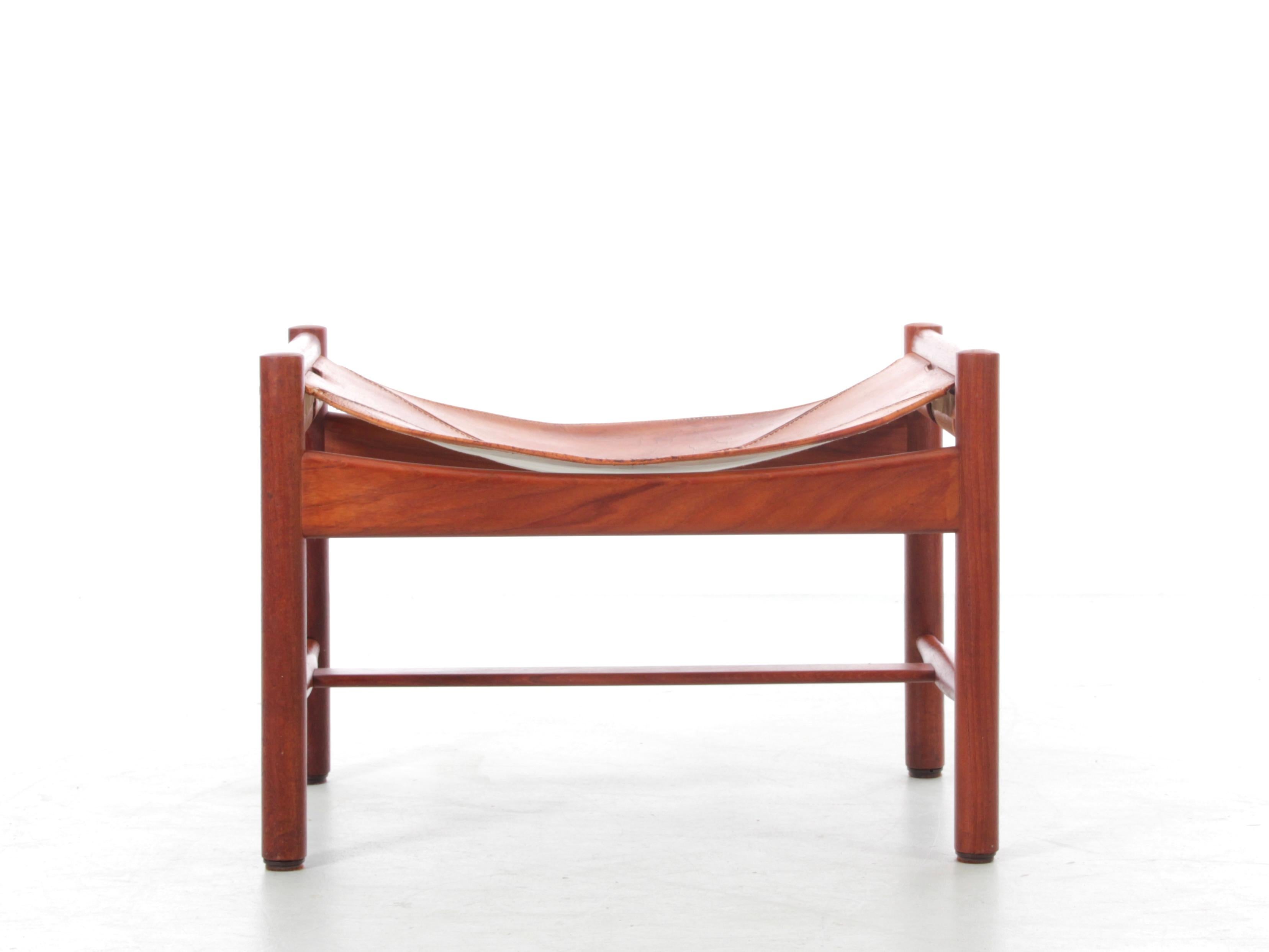 Mid modern Scandinavian ottoman by Kurt Olsen in teak and leather. This footstool features a teak frame paired with its original natural leather seat, which exhibits a charming, enduring patina suitable for everyday use. Its rounded legs and