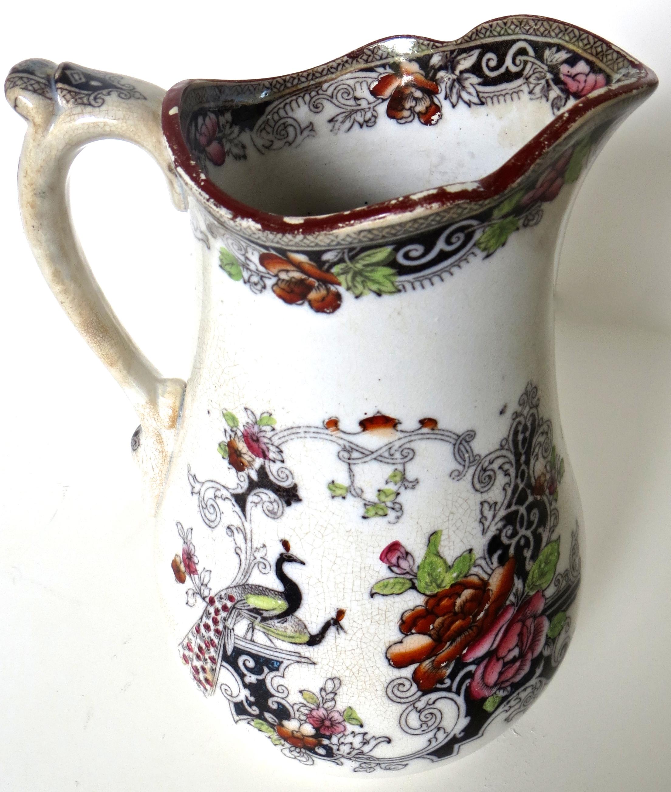 Nice example of an ironstone pitcher, hand painted from copper plate transfers in the Chinese Manduran pattern depicting peacocks and abundant floral decoration in a Famille Rose style (see image). Design was made popular by Mason's company, albeit,