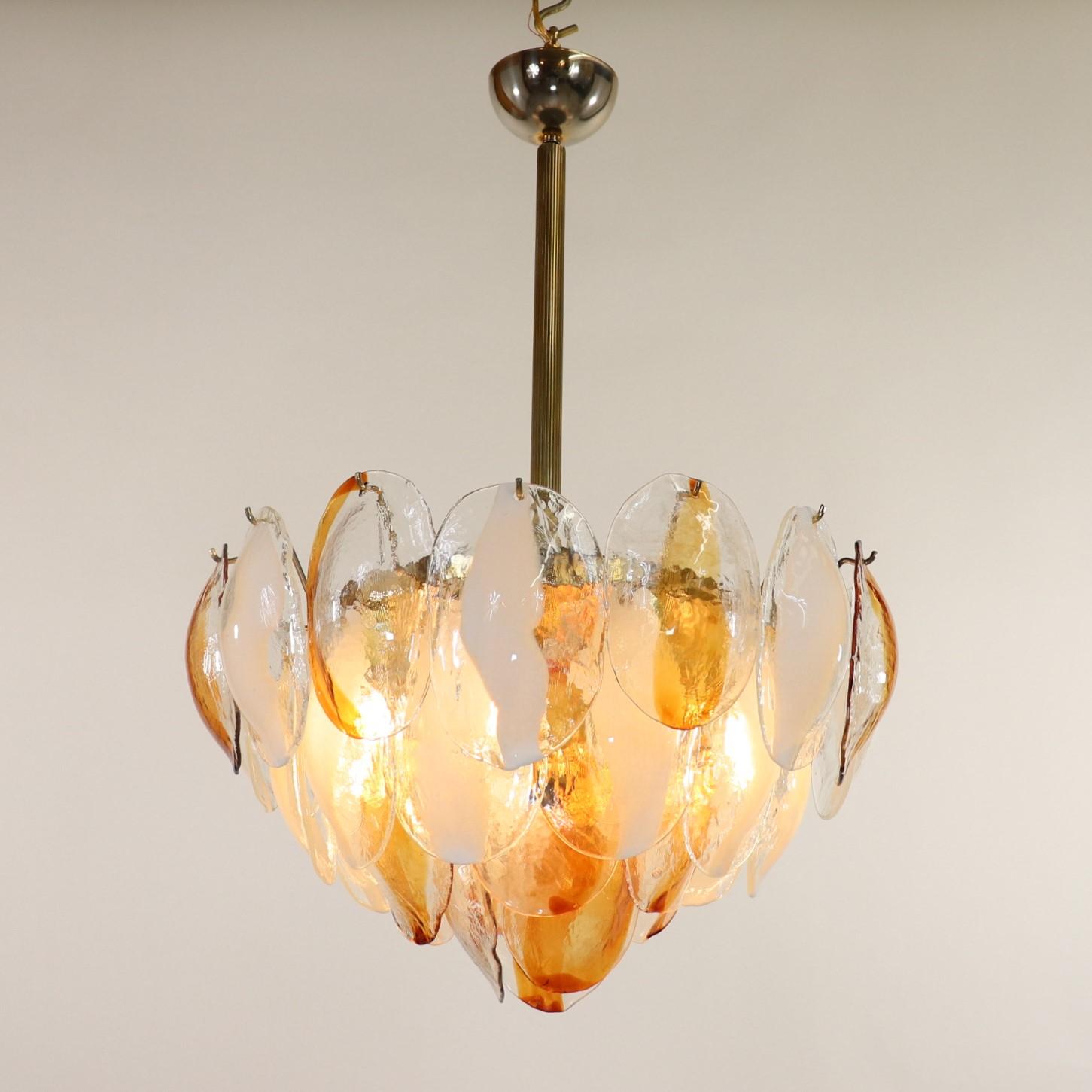 Eleva il tuo spazio con questa raffinata lampada a sospensione in vetro di Murano di La Murrina. Questo lampadario è caratterizzato da tre livelli di conchiglie in vetro Cristallo, ognuna delle quali presenta strisce centrali bianche e ambrate.