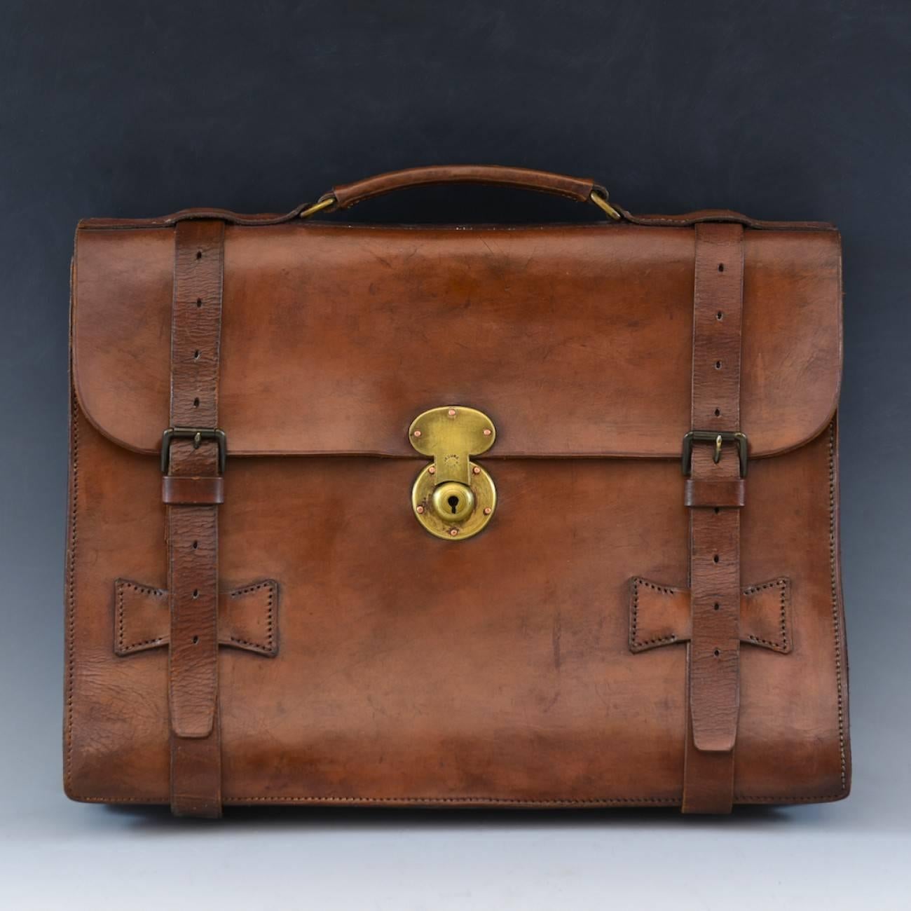 A splendid mid tan leather three pocket flap-over briefcase with two buckled straps and central brass lock, circa 1940.

Dimensions: 40 cm/16 inches (length) x 31 cm/11¾ inches (height) x 5 cm/2 inches (thick).



   