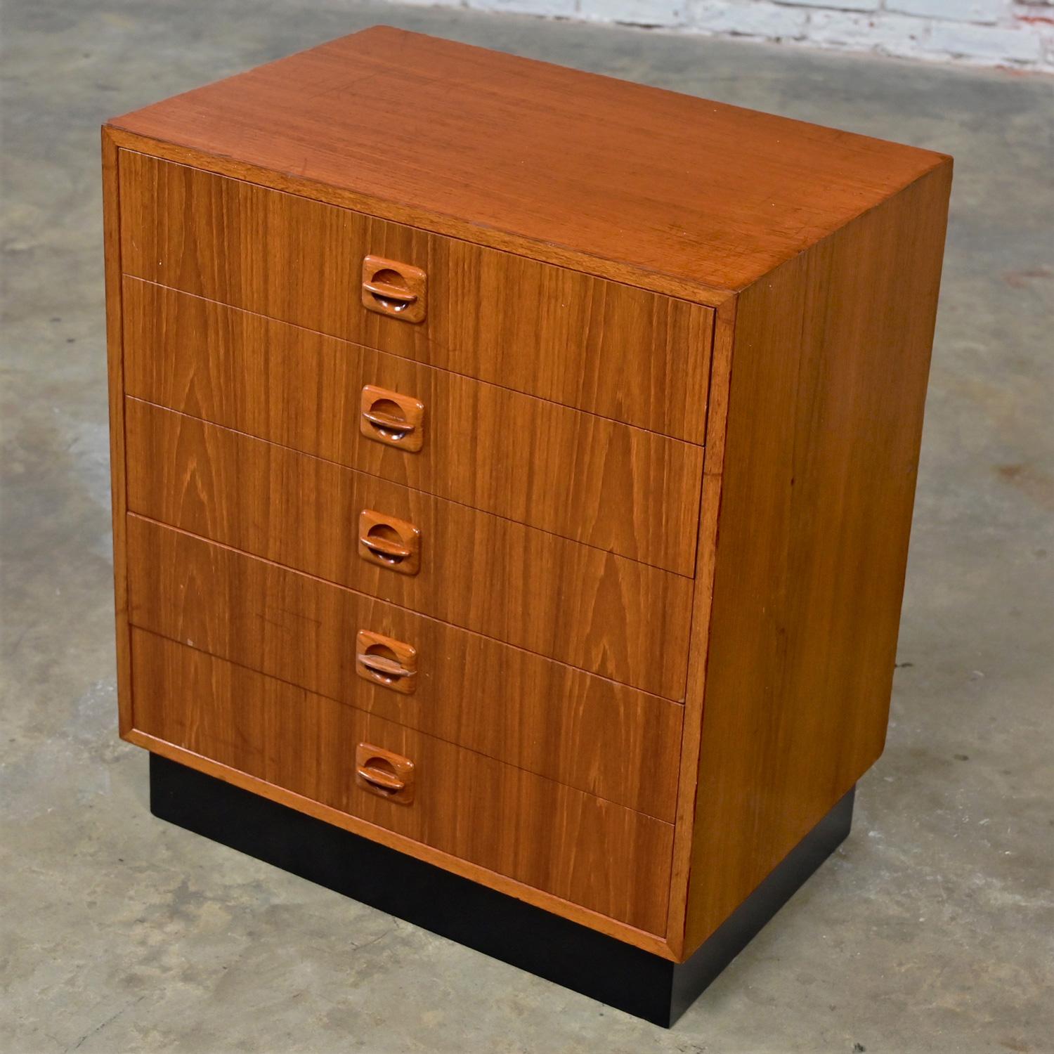 Lovely Mid to Late 20th Century Scandinavian Modern teak cabinet with 5 graduated drawers, sculpted teak pulls, & a newly added black painted plinth base. Beautiful condition, keeping in mind that this is vintage and not new so will have signs of
