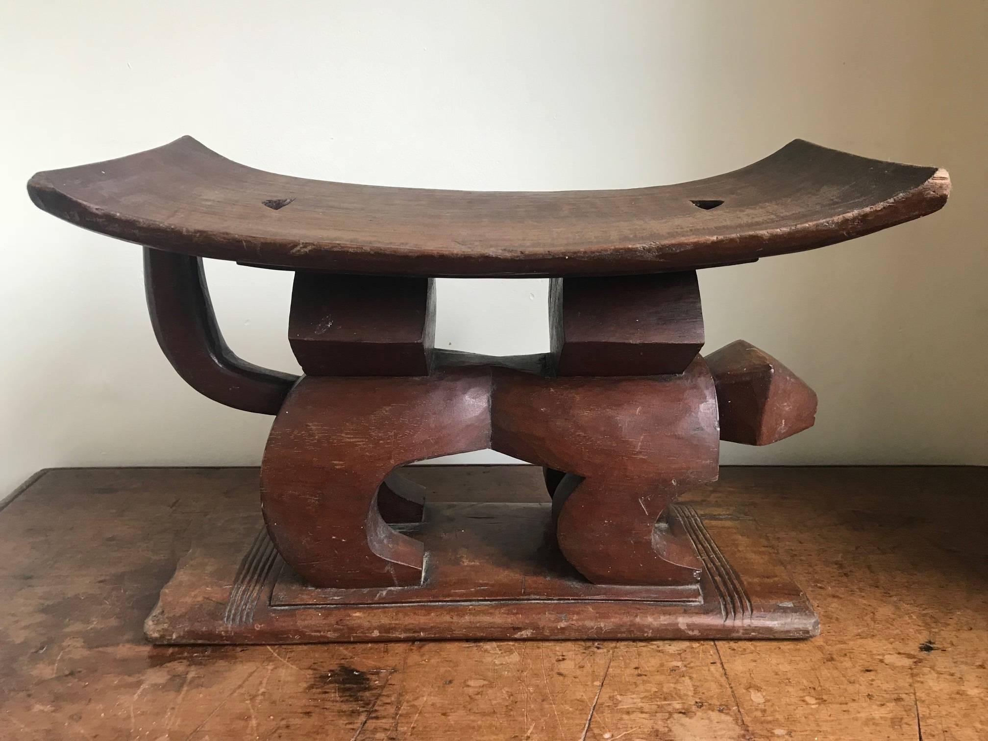 A very interesting African tribal stool. Possibly from the Ashanti tribe featuring an animal as its base carved in a geometric Art Deco style. Some wear and tear, which should be visible in the photos. Original patination.