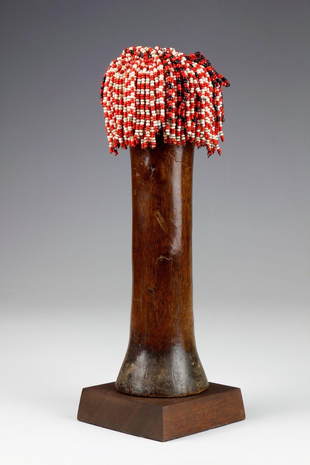 Esta muñeca de cuentas de mediados del siglo XX, probablemente originaria de la región costera de Kenia, alrededor de Mombasa, presenta una forma poco común, con un aspecto antropomorfo maravillosamente simplista y abstraído. Tallado en una madera