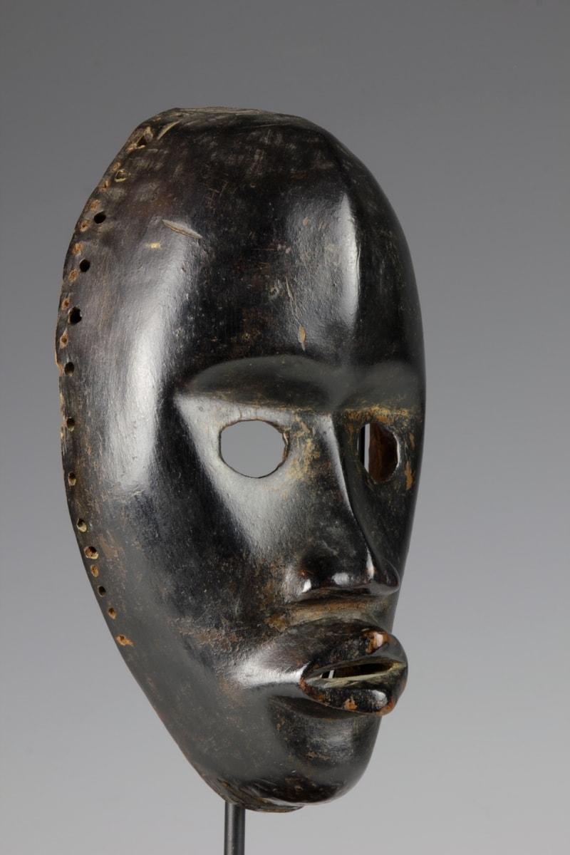 This finely carved mid-twentieth century 'zakpai' mask, from the Dan culture in the Ivory Coast, reflects Dan conceptions of beauty. With its rounded eyes, accentuated cheekbones and protruding open lips, the mask displays refined facial features. A