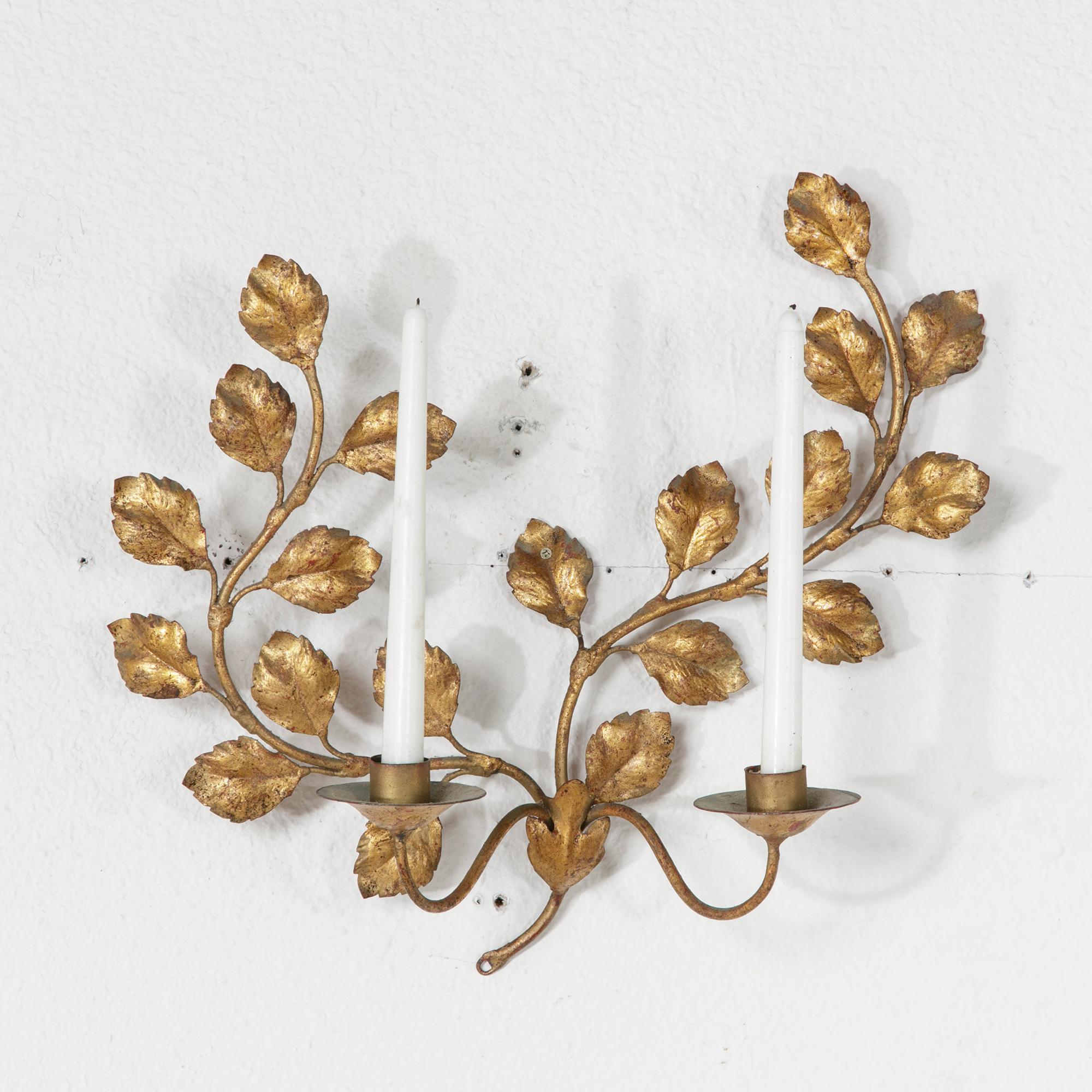 This mid-twentieth century French gilt metal wall sconce is attributed to the French design house, Maison Bagues. The sconce is fitted for two candles and features scrolling branches of leaves. c. 1960.