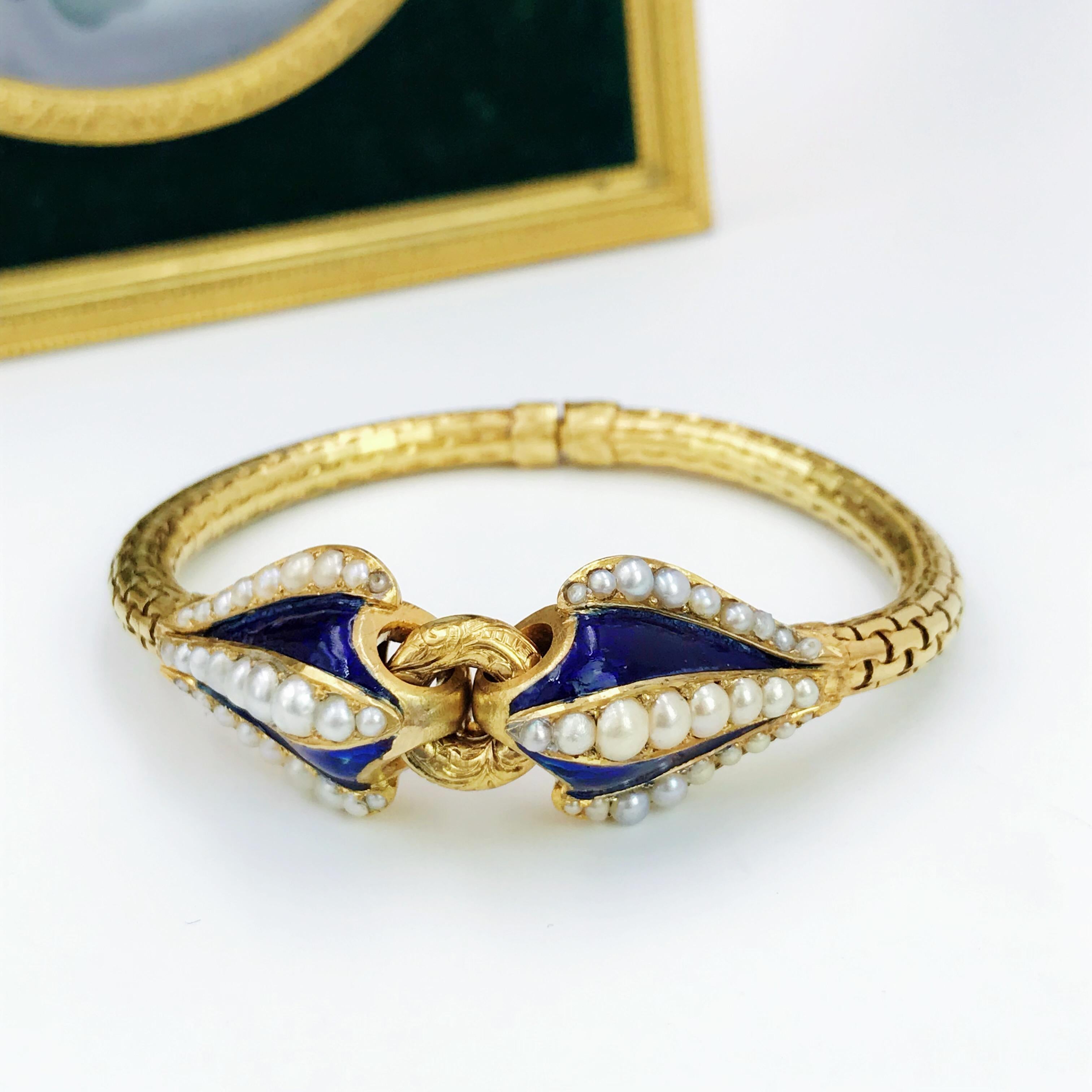 A mid-Victorian 18 Karat gold split pearl and enamel bracelet. Designed as two blue enamel tapered panels, each with graduated split pearl scrolling central line and sides, either side of a foliate engraved circle, to the fancy-link sides and