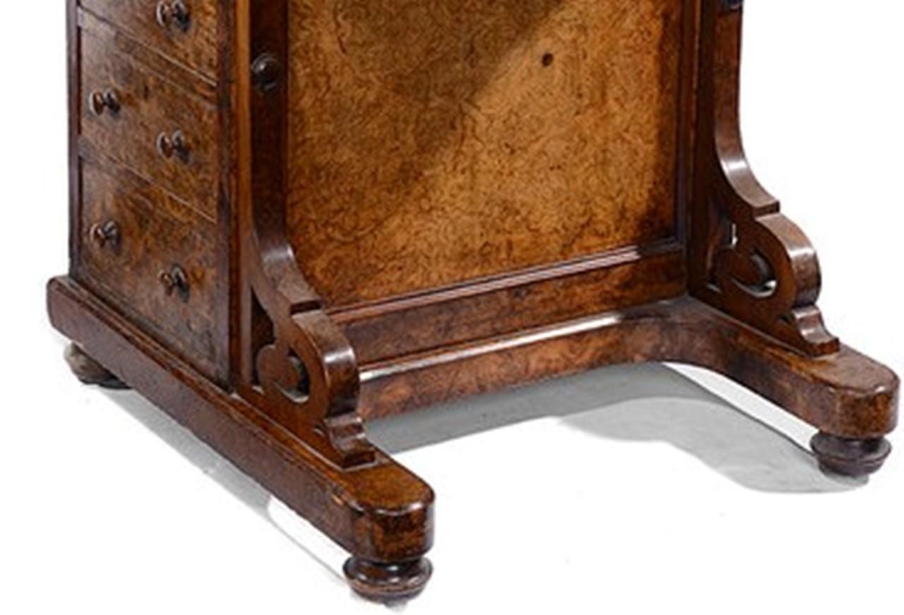 A mid Victorian burr walnut Davenport.
The raised stationary and pen and ink department to the top back with a rising lid.
The rising desk top with a tooled inset red leather writing surface, opens to reveal a satinwood lined interior.
To one side