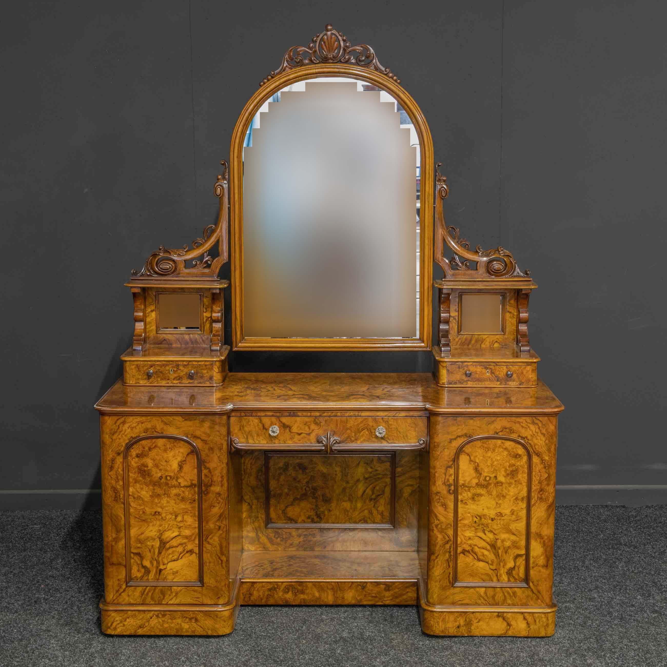 A superb mid Victorian burr walnut veneered dressing table of the highest quality. The two end cupboards open to reveal four solid mahogany drawers with recessed turned knobs. Both cupboards with locks and keys. The upper section has a pair of lined