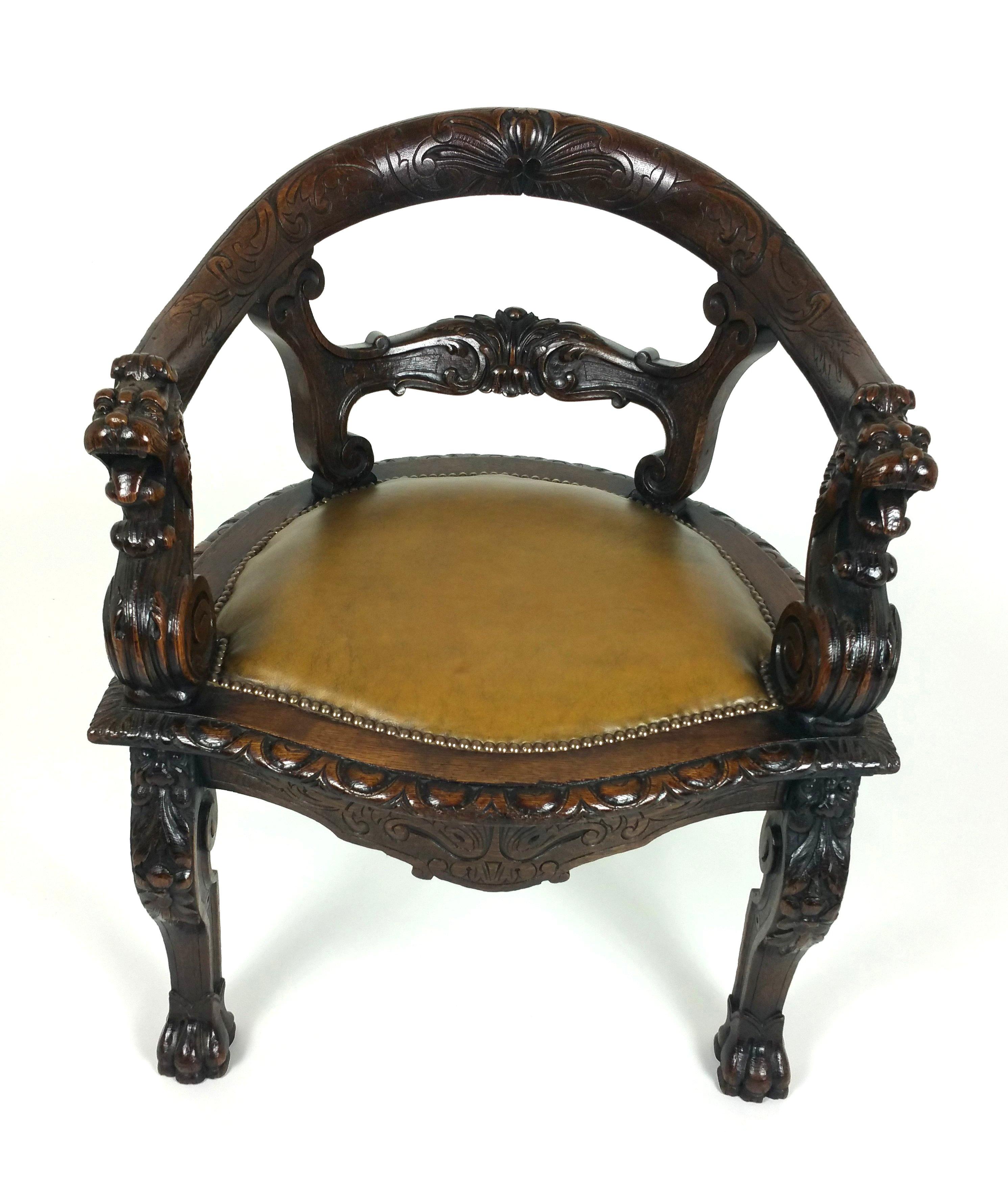 This superb and very handsome mid-Victorian oak tub shaped desk chair is decorated with detailed carvings of scrolls around the entire front of the chair and finished with a lion’s head on each arm rest end, as well as the top of the front legs. The