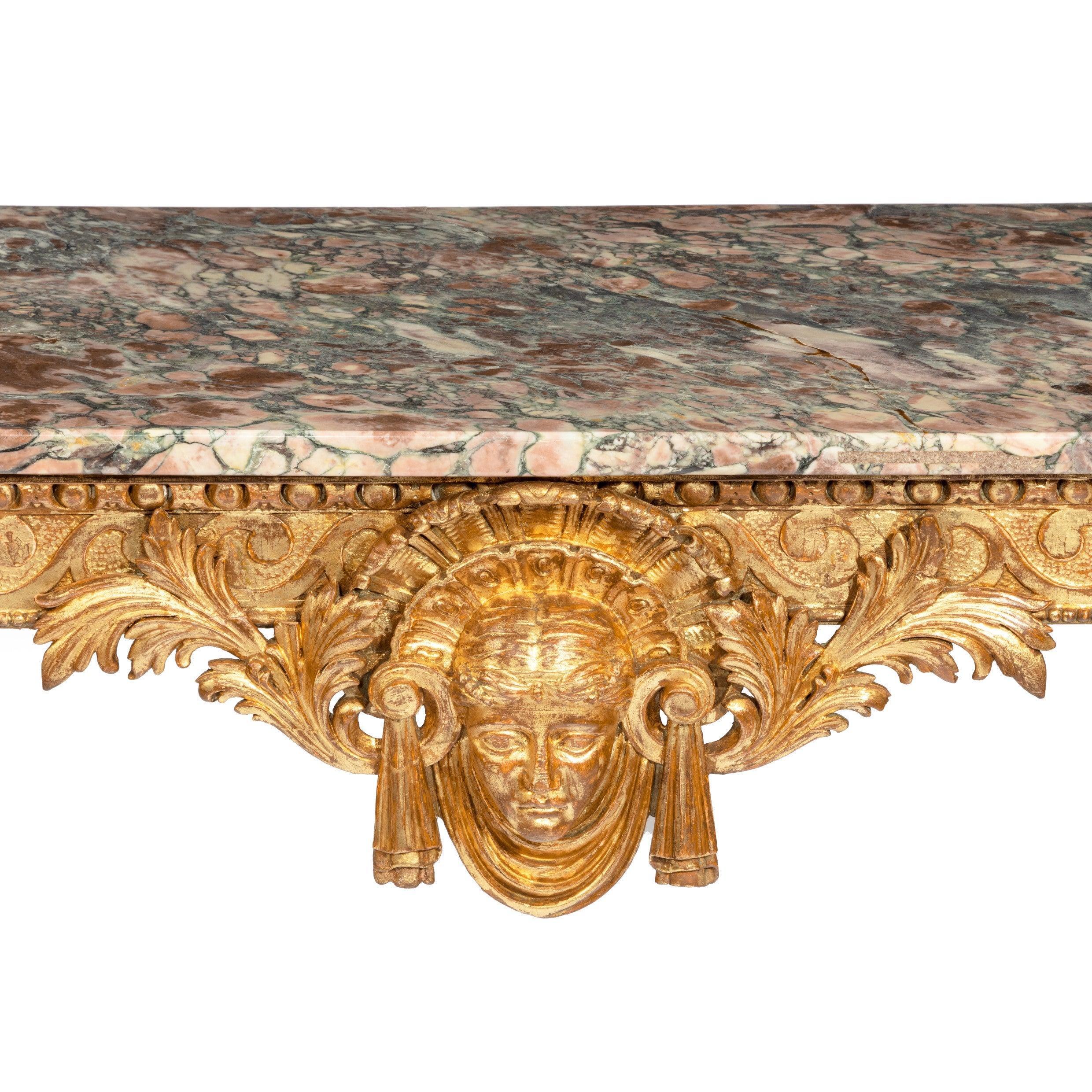A mid-Victorian giltwood console table, of rectangular form, the frieze with Vitruvian scrolls centred on a classical female mask wearing a feathered and tasseled headdress flanked by scrolls and foliage, raised upon cabriole legs with acanthus