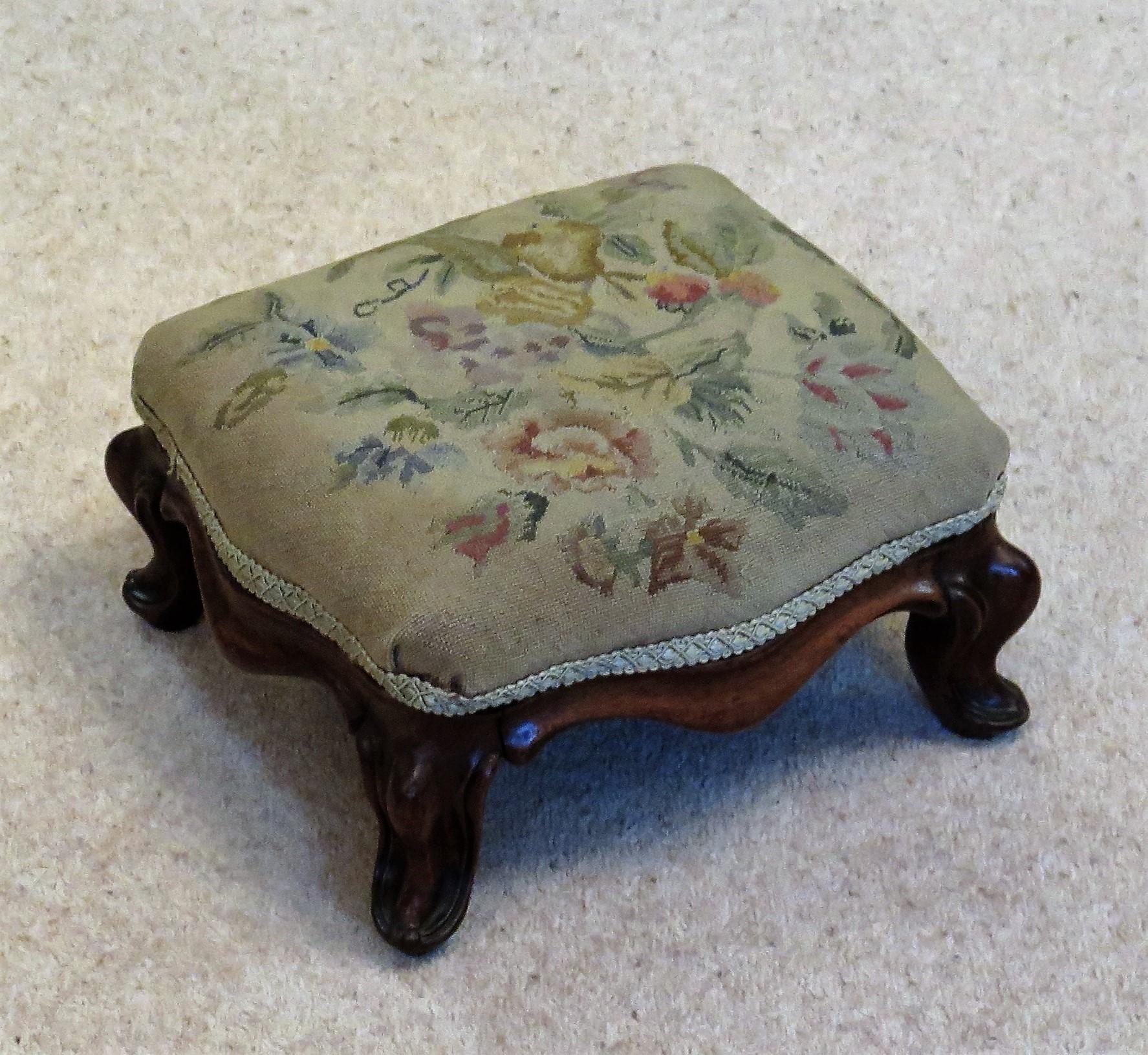 This is a very good quality English Victorian period, hardwood framed stool or foot stool with its original woven tapestry cover, circa 1850

The stool is rectangular in shape with a carved solid hardwood, possibly walnut, frame having curved and