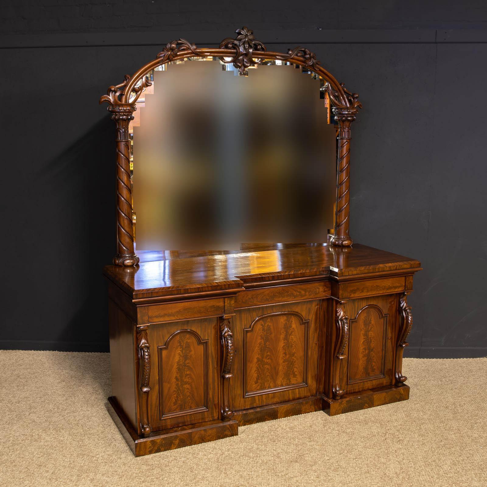 A mahogany sideboard from the mid Victorian period. The carved cabriole supports to the cupboard doors hide brushing slides to the left and a cellarette drawer to the right and shelf in the centre. All doors have working locks and keys. Above the